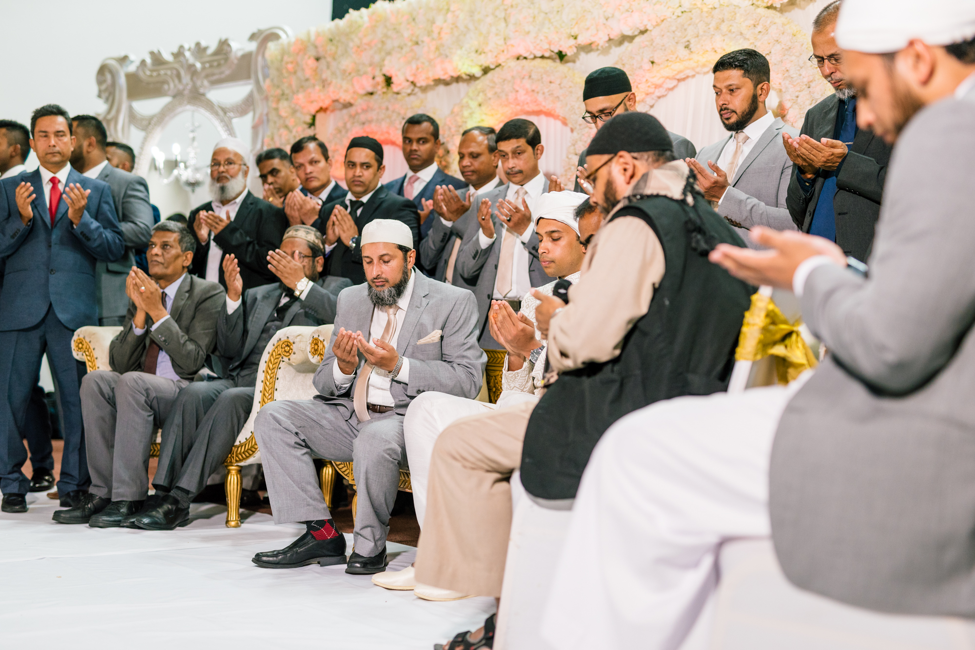 members of the grooms family sit in prayer before the start of the wedding ceremony