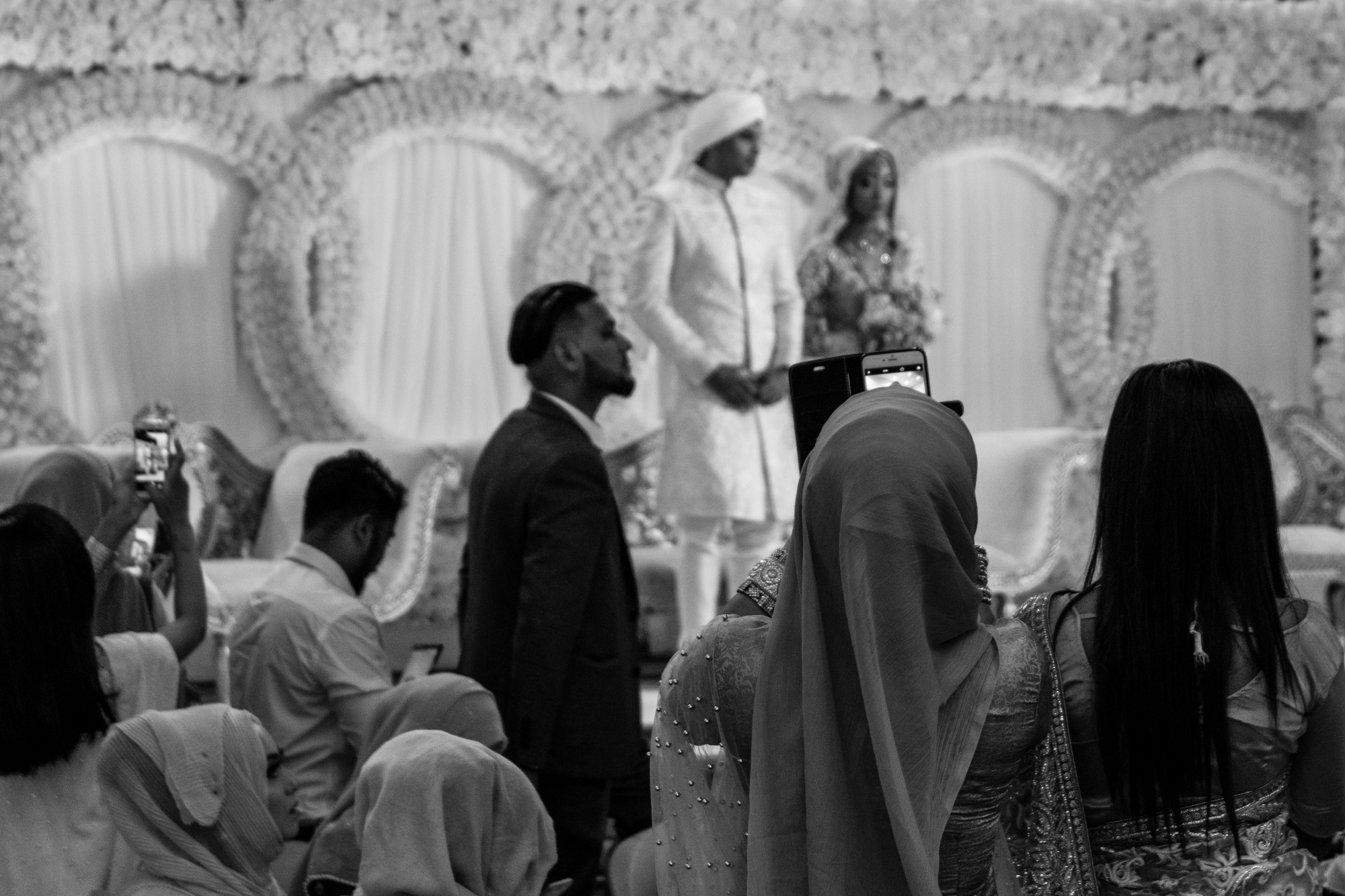 the bride and groom stand proudly facing all their friends and family on the stage