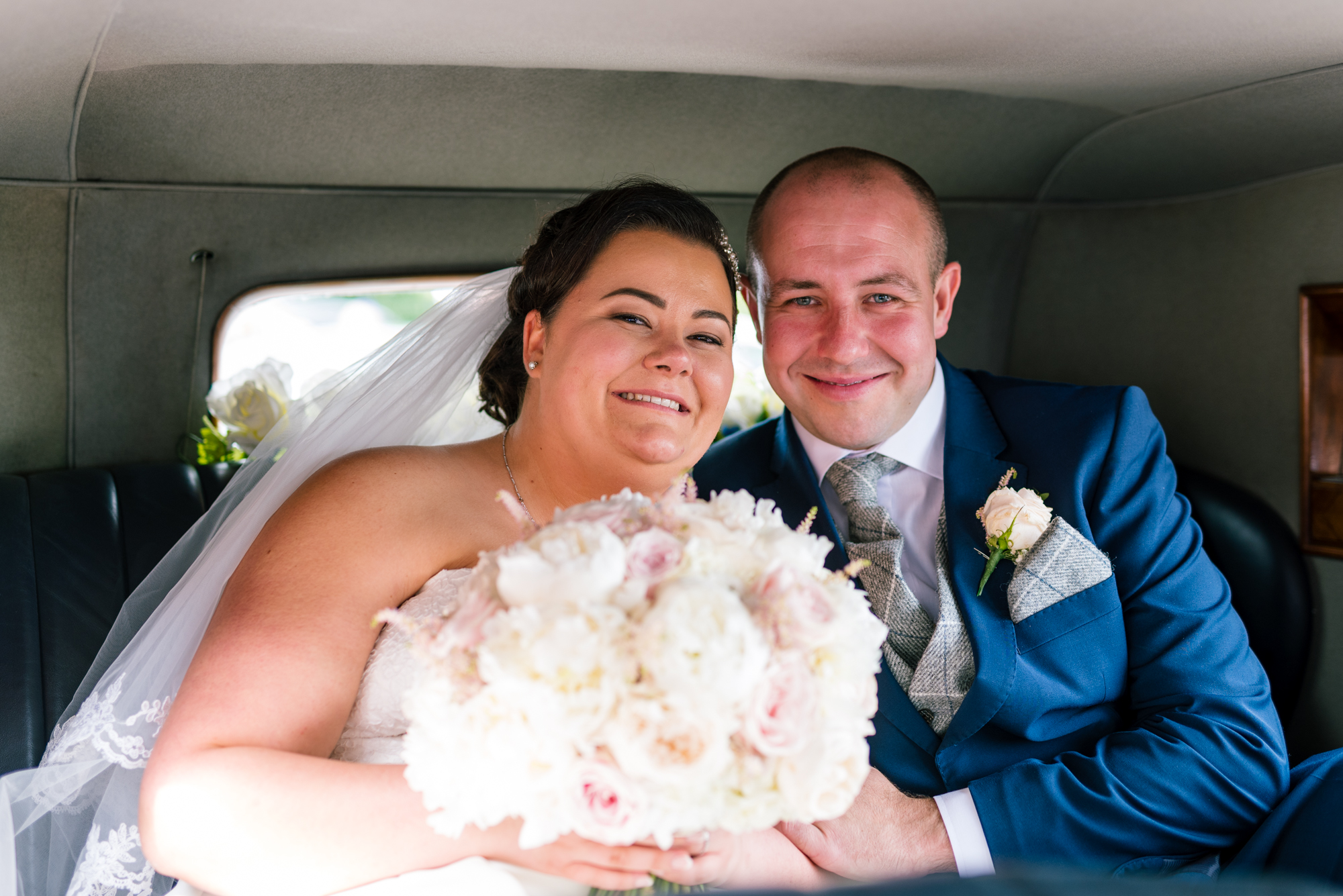 happy bride and groom inside the wedding car