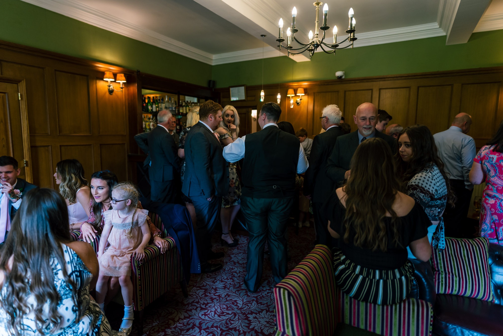 Wedding guests gather in the bar