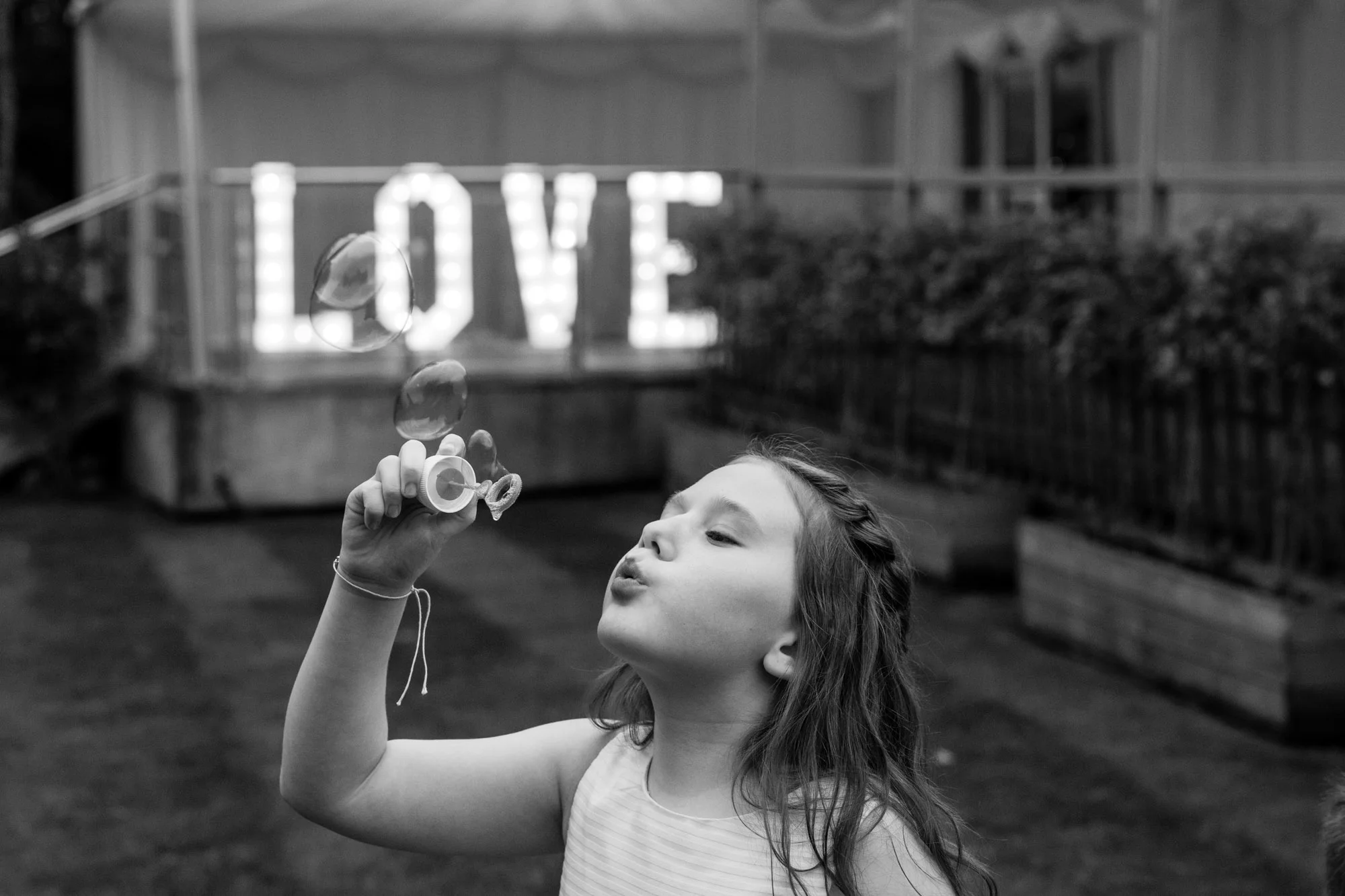 child blowing bubbles at a wedding