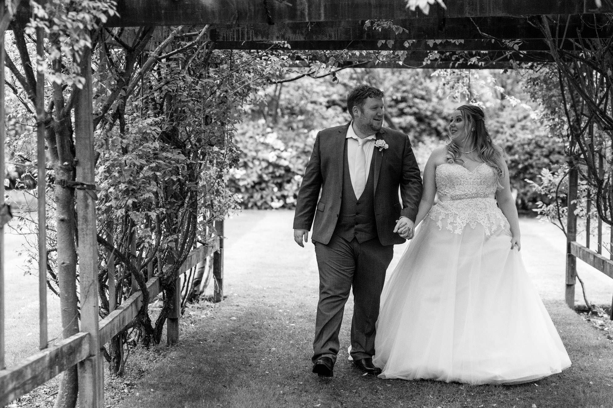 bride and groom walking in the grounds of nunsmere hall