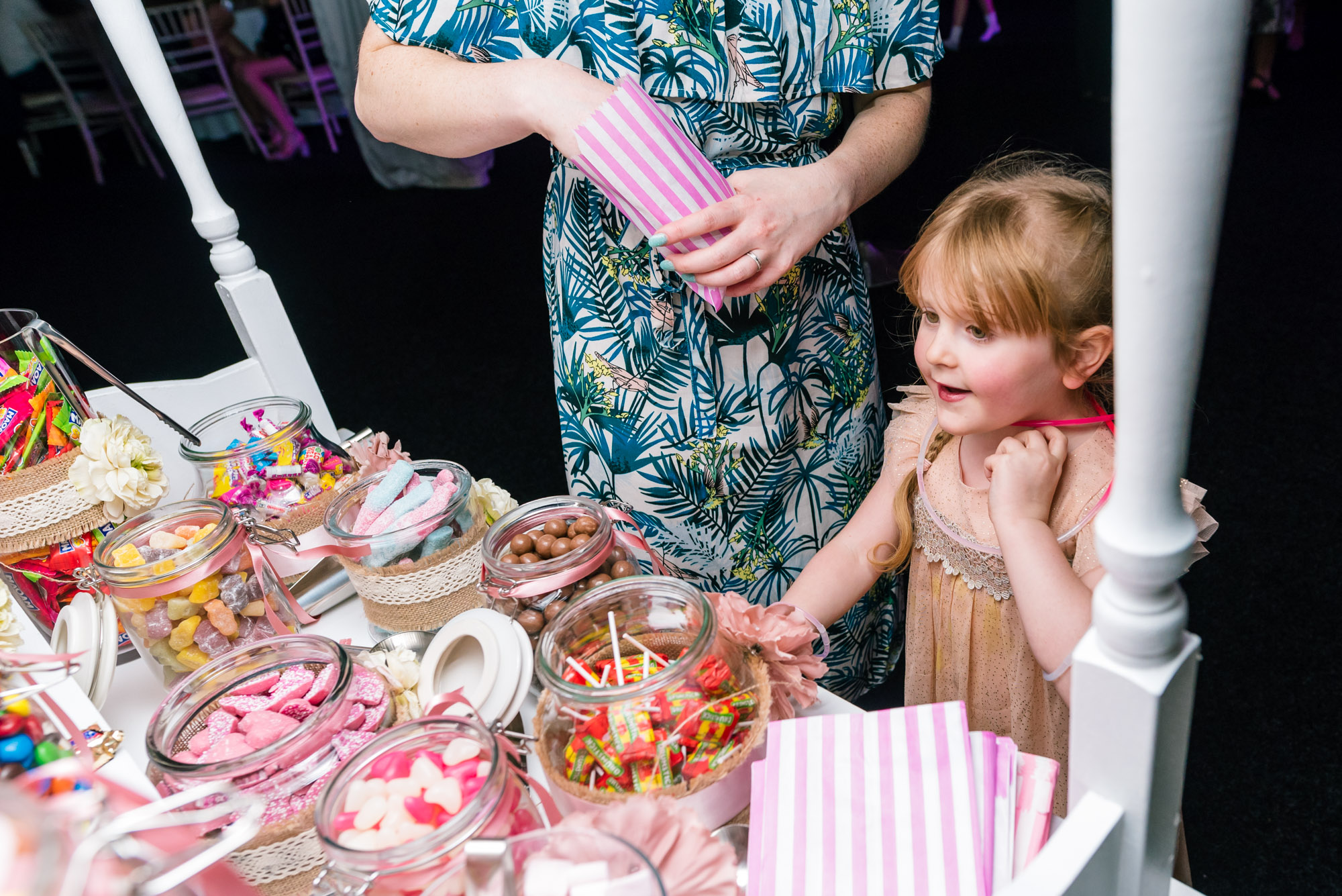 child getting sweets from the candy cart