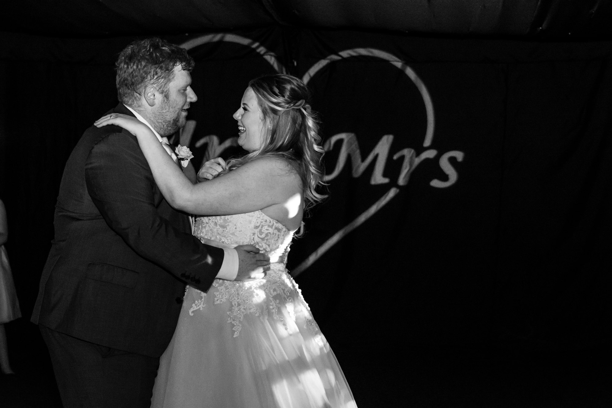 bride and grooms first dance with love letters behind them