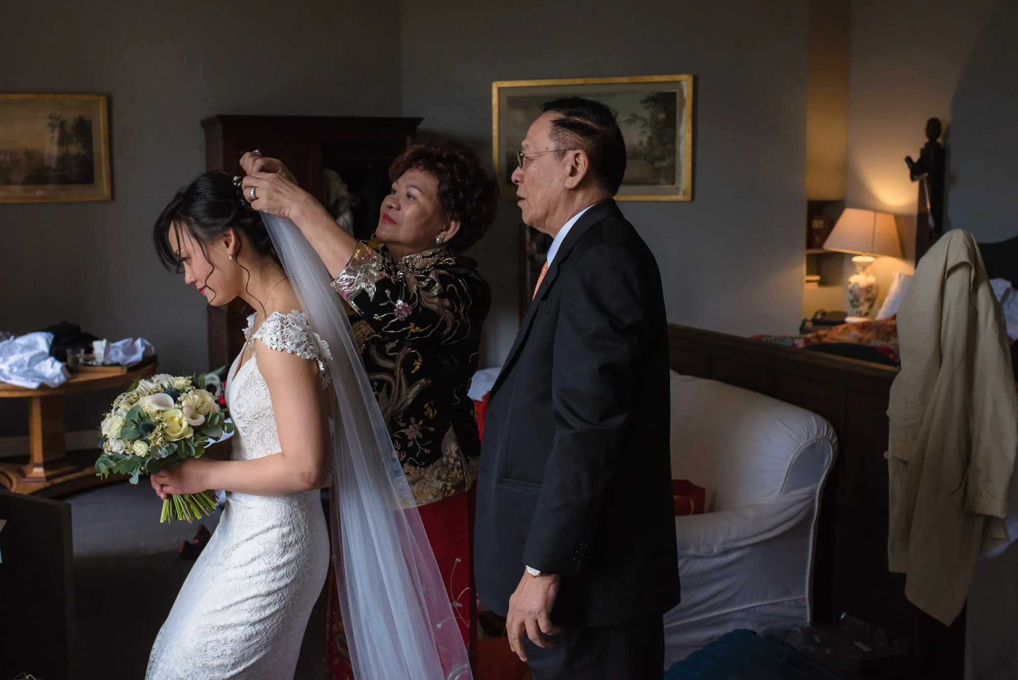 The brides mother and father put her veil in.