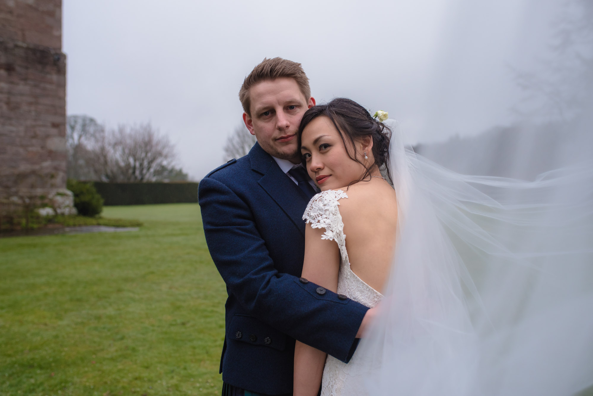 The bride and groom cuddle together during their wedding photography portraits.
