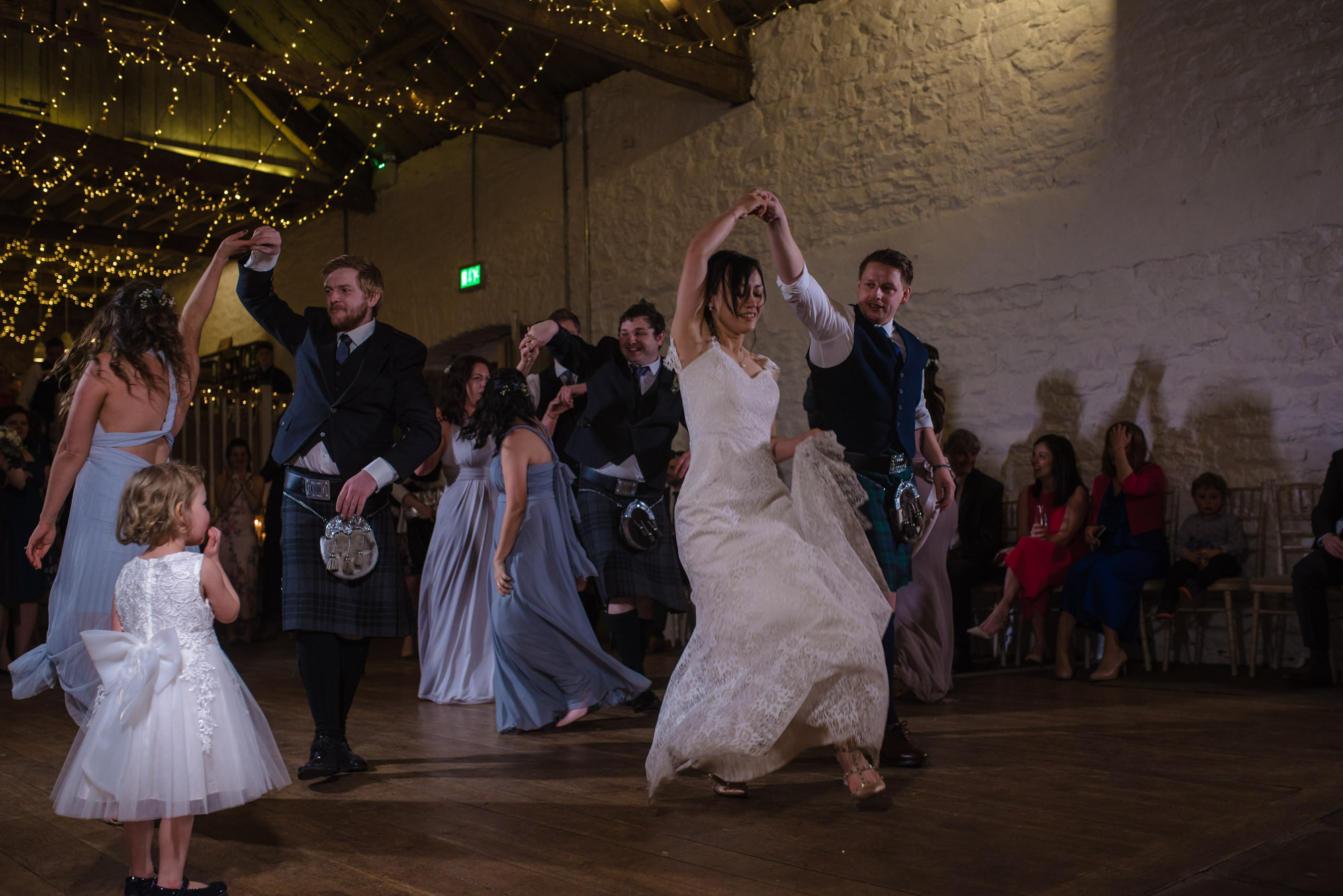 The bride and groom share their first dance with all their guests on the dance floor.