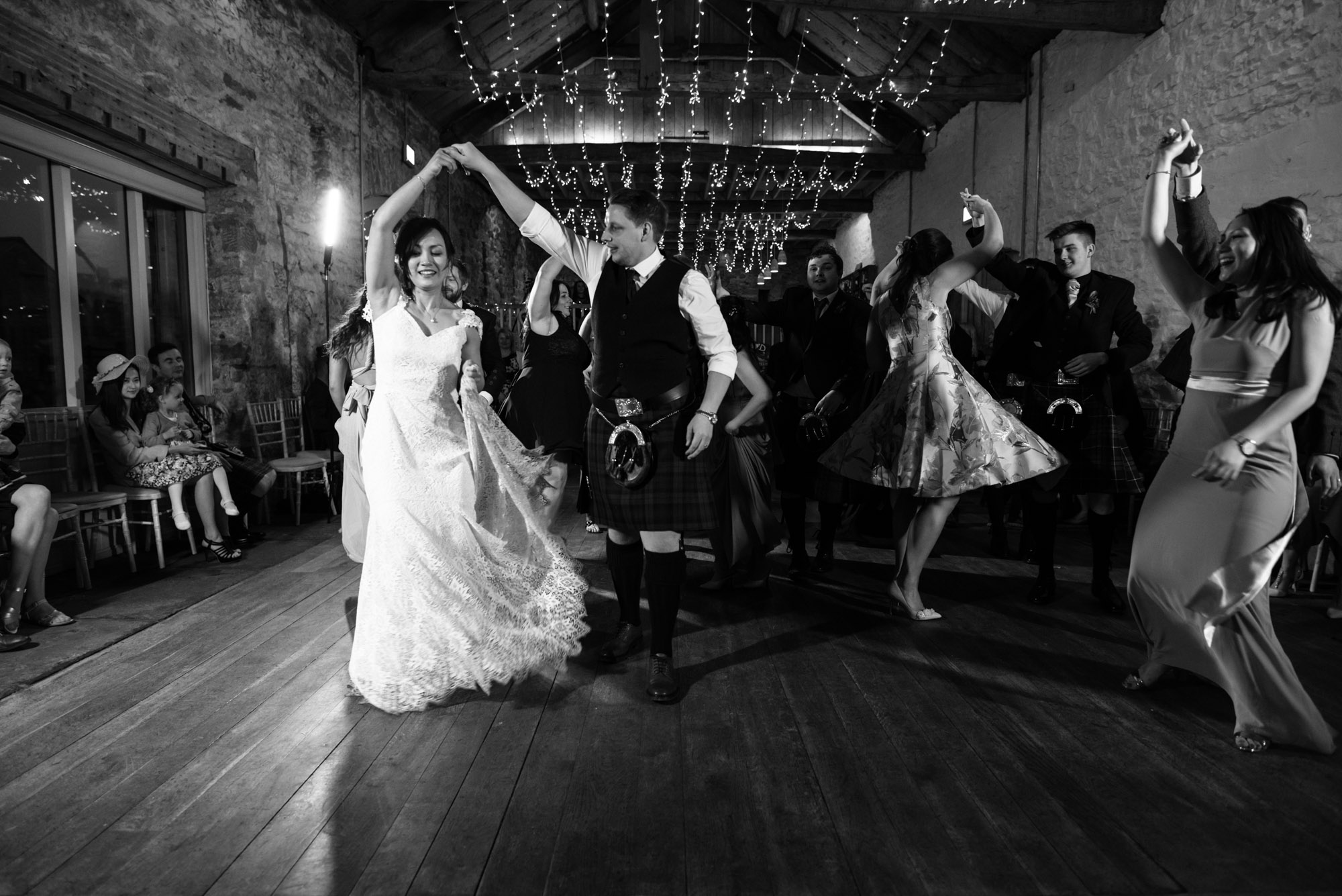 Black and white photo of the bride and groom dancing the gay Gordon’s.