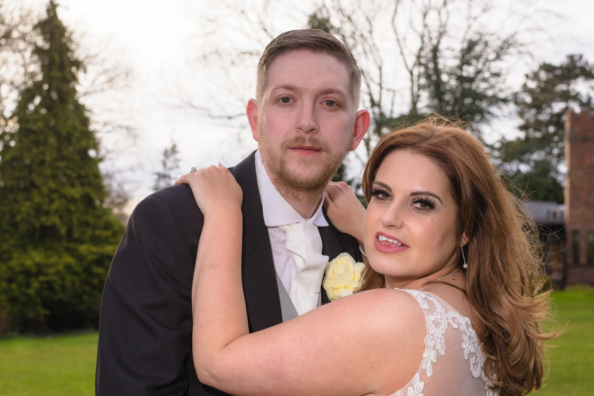 The bride with long brown hair and very tall husband stand and pose for the camera.