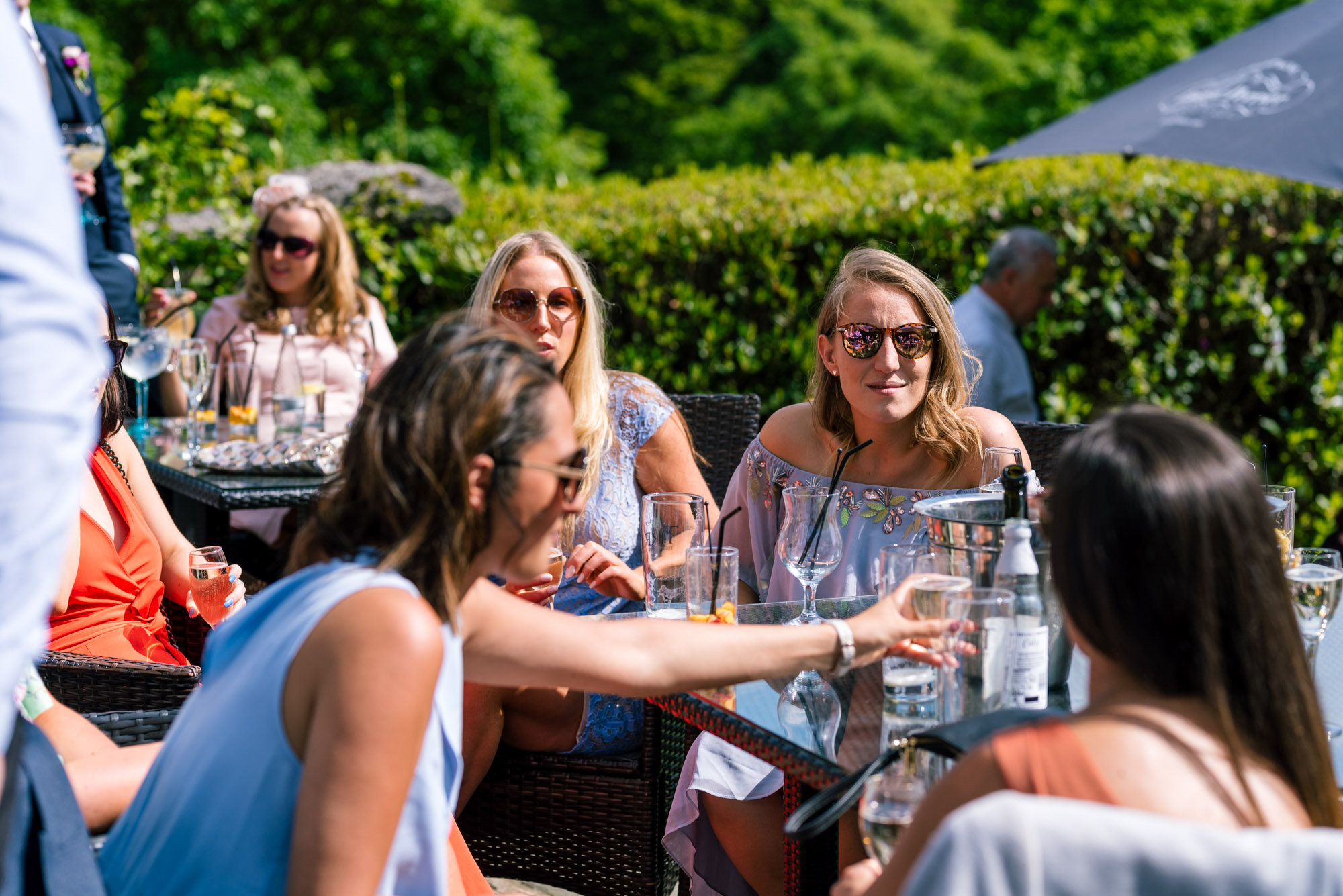 Friends sit in the sun to enjoy a drink