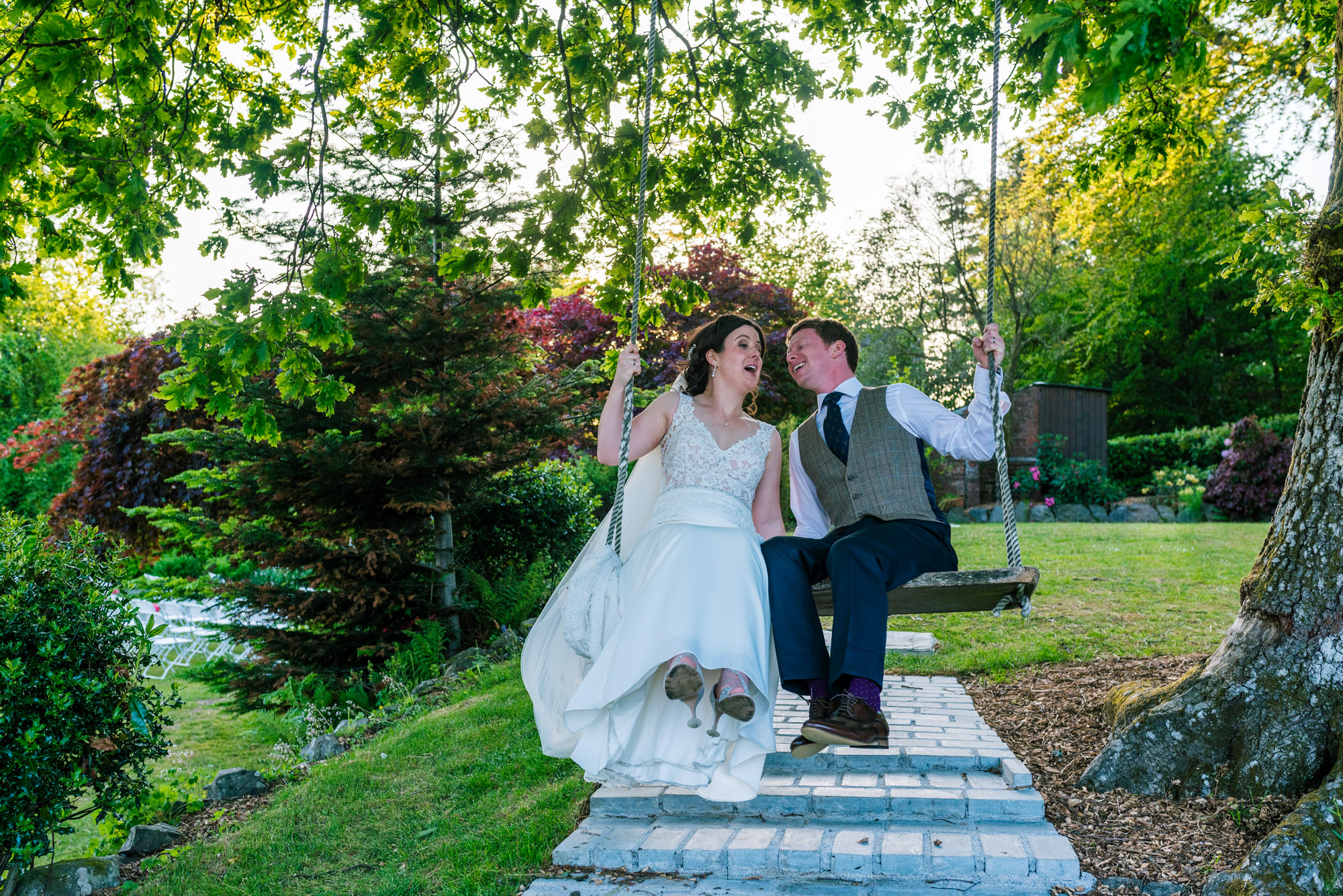Bride and groom enjoying the swing in the garden