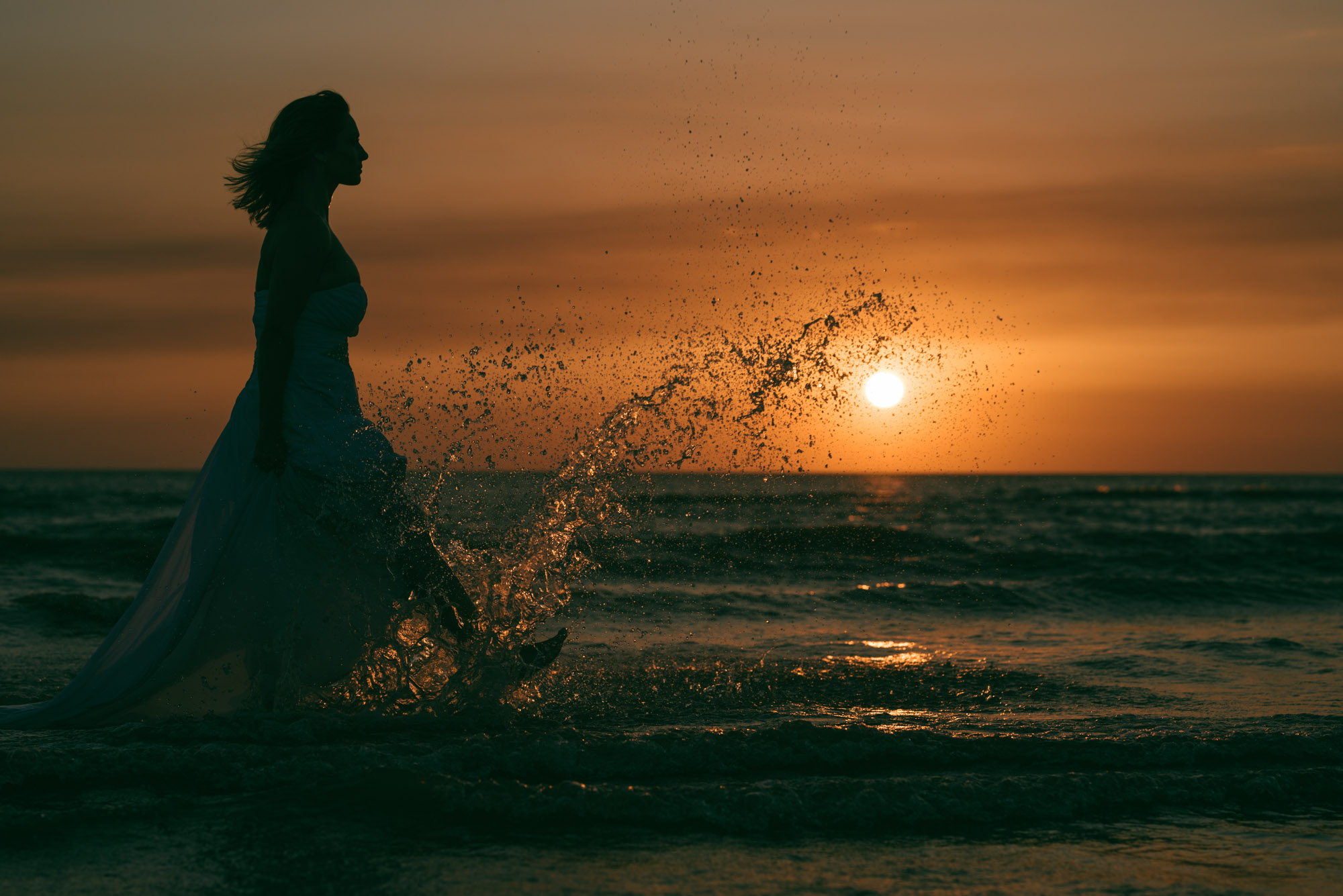 Bride in the sea, kicking up a splash