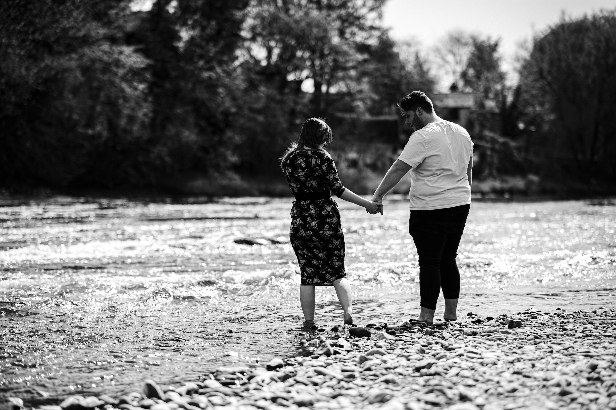 Couple holding hands standing in the river