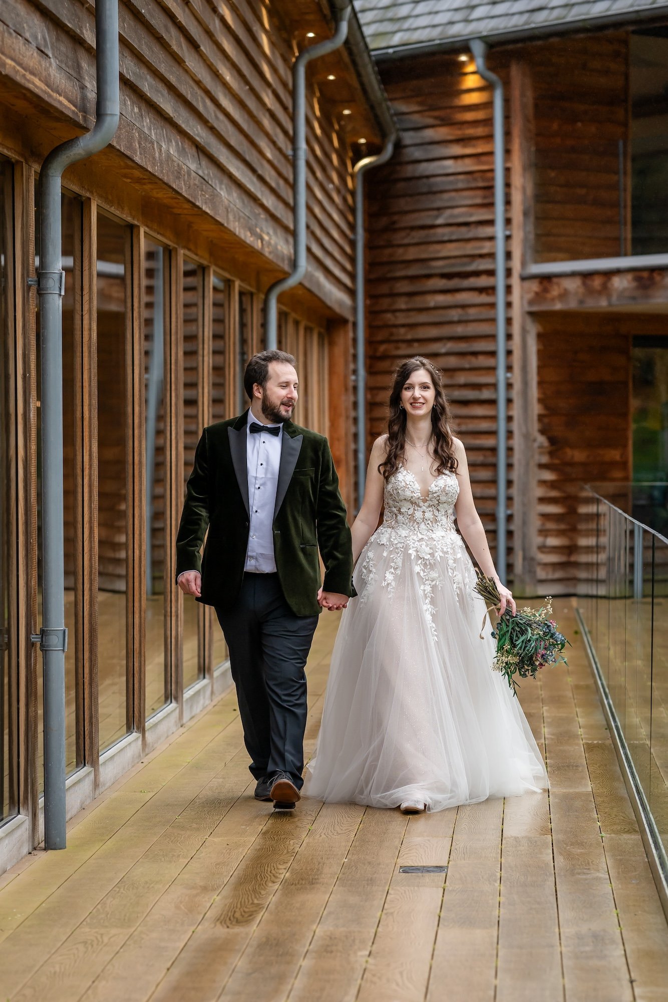 Jen and Tom walking the decking at The Mill Barns Wedding Venue