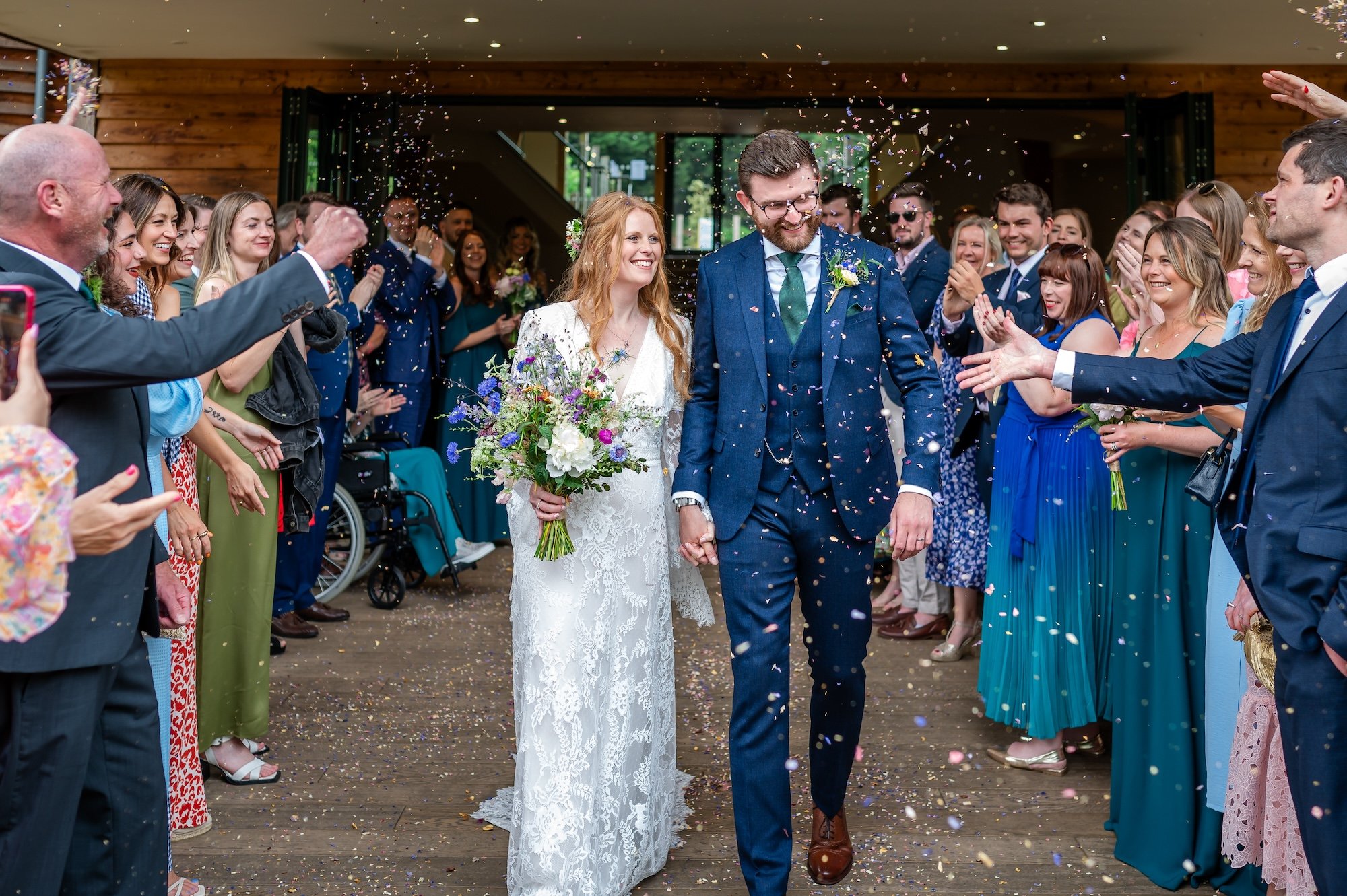 Rhian and Josh in the confetti on the decking at The Mill Barns Wedding Venue