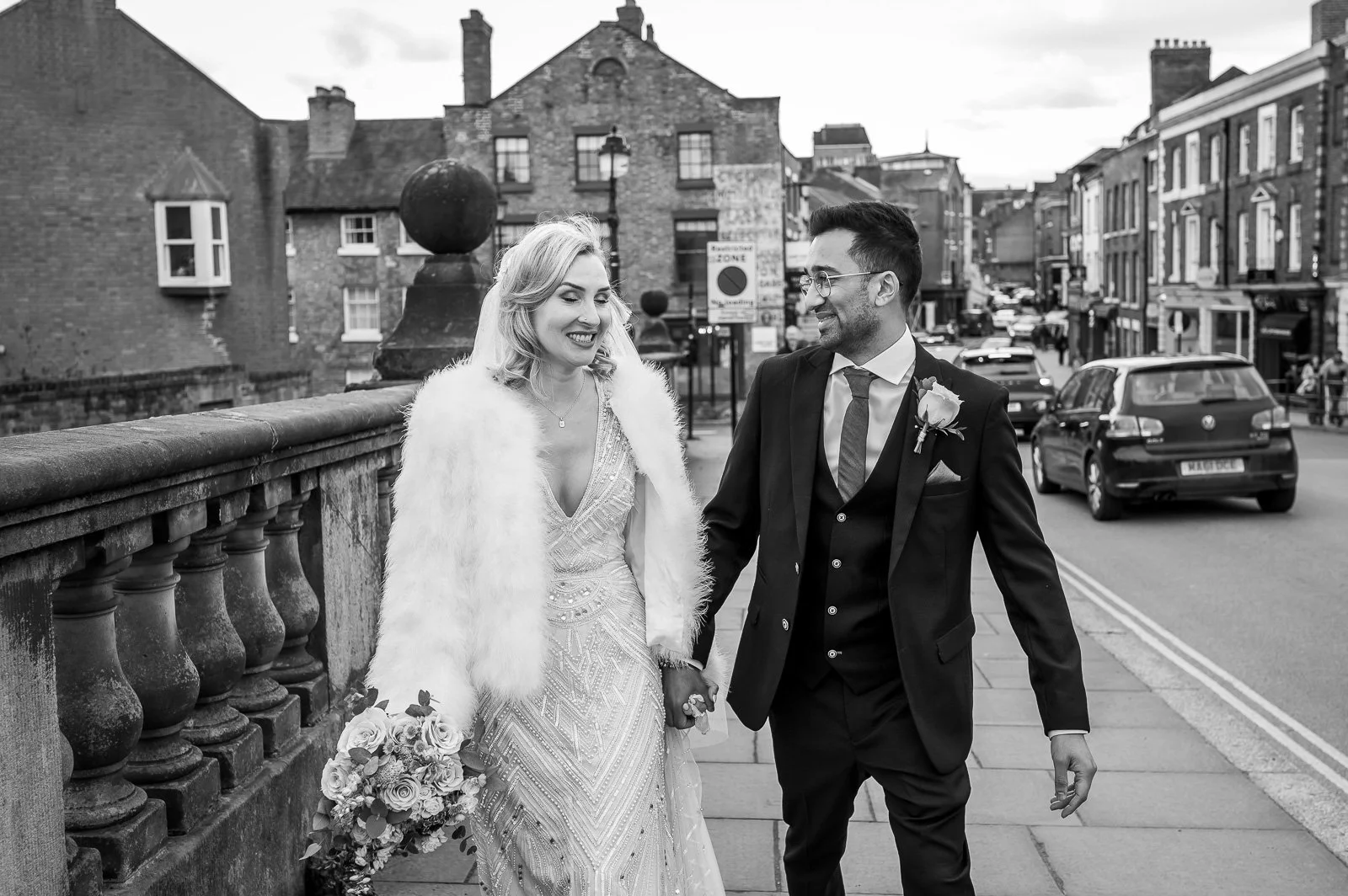 Bride and groom walk through a town