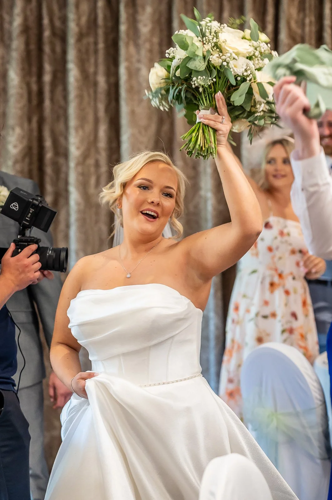 Bride holding her bouquet aloft