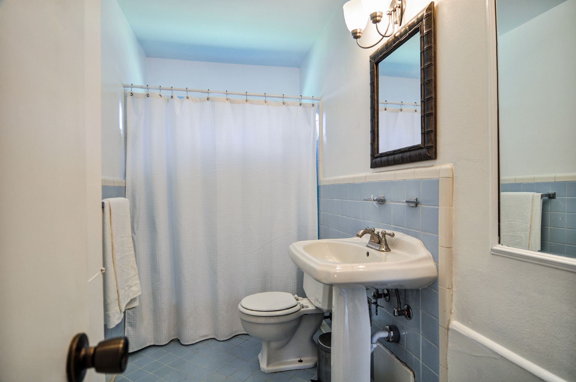  Vintage hall bath with extra storage behind the door 