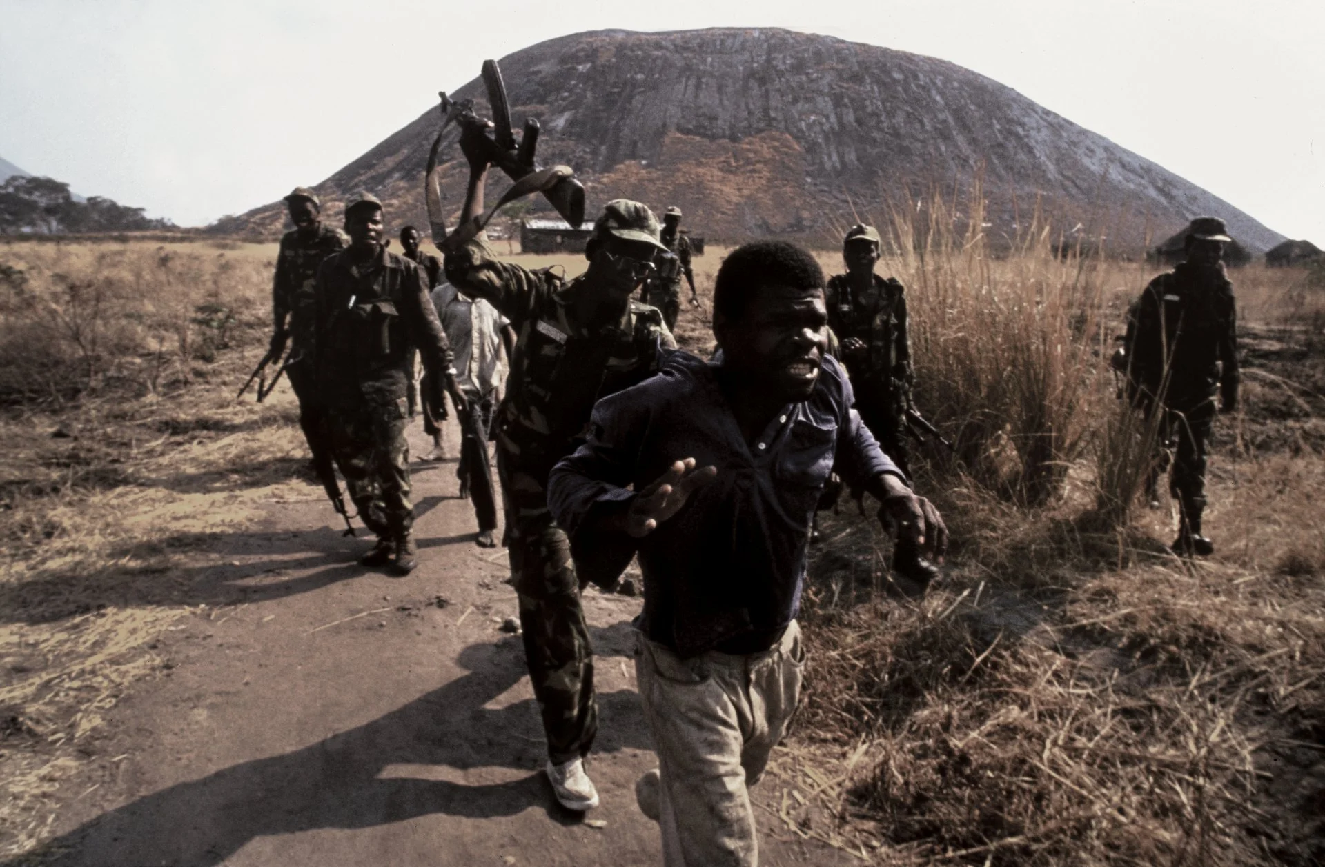 A young man is viciously beaten (he refused conscription) by MPLA soldiers during Angola's long-running civil war. 1993