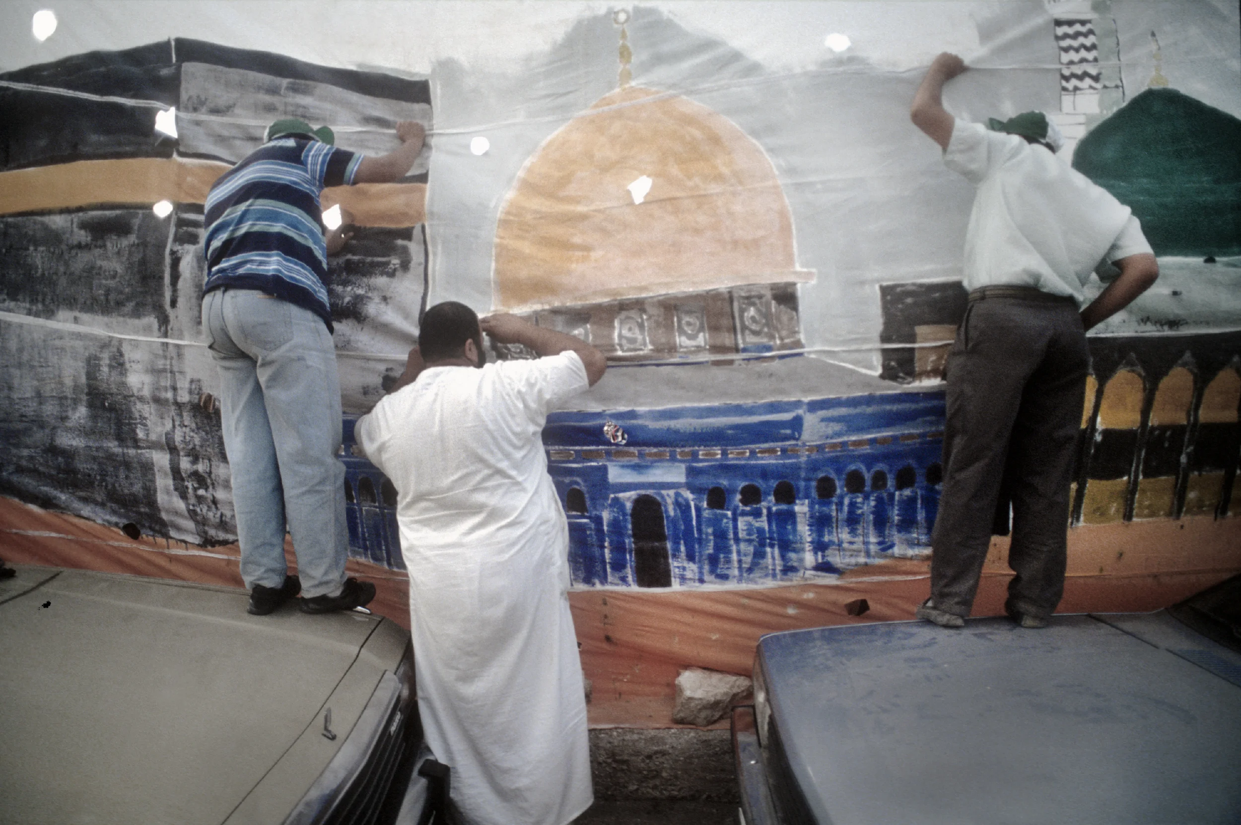  Men peer at an Anti-American protest taking place in Amman, Jordan. 1991 