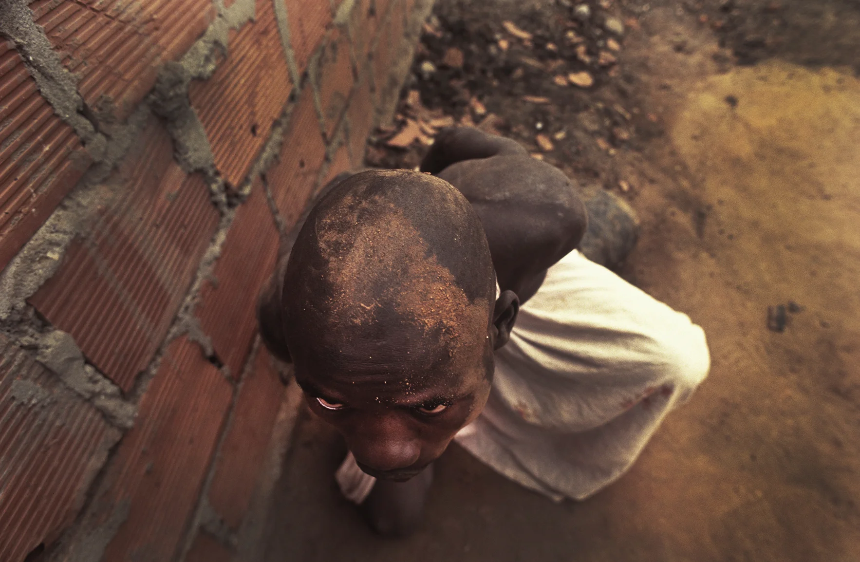 A former combatant of Angola's long running civil war is chained to an engine part at Papa Kitoko's mental asylum, Luanda, Angola, 1993