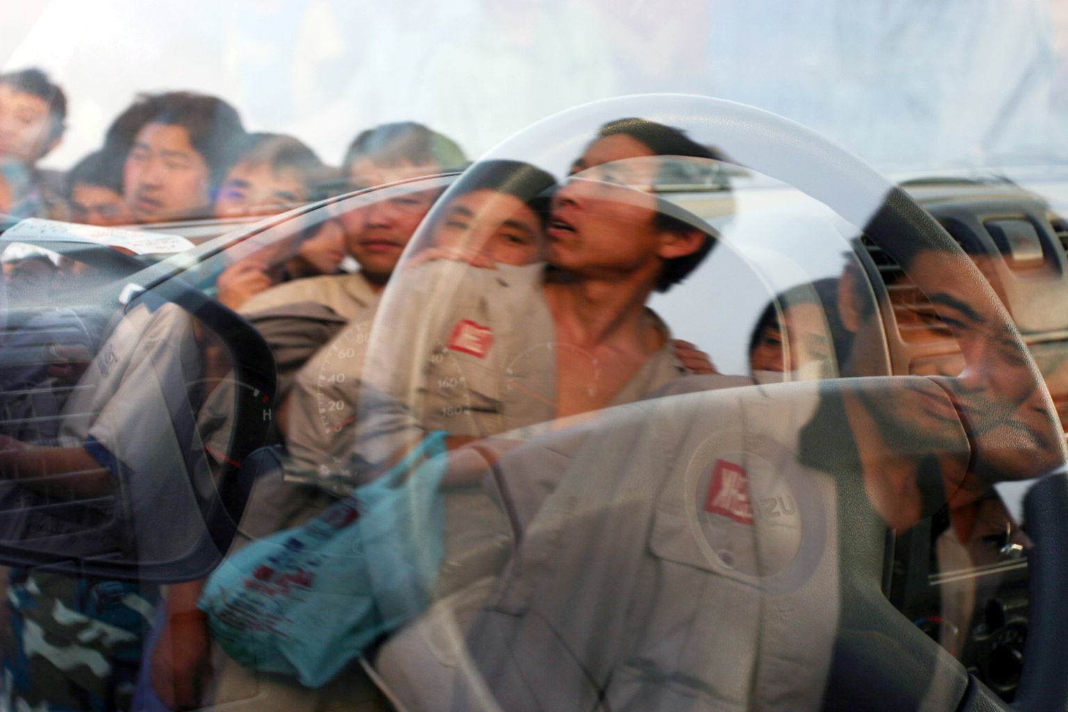  Indian and Chinese immigrant workers queue for a bus to work. Dubai, 2007 