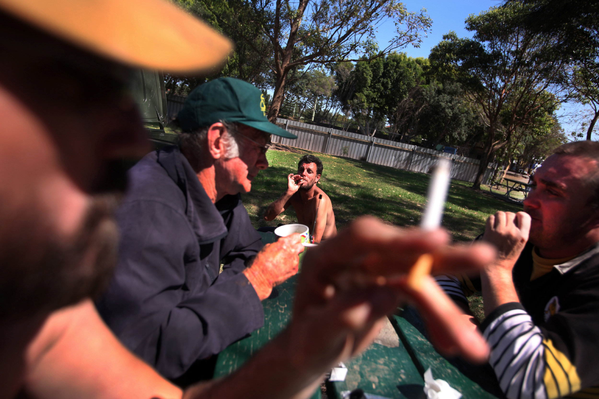 Tas (foreground and left), Dennis (Green baseball cap) drink with friends in a local park.