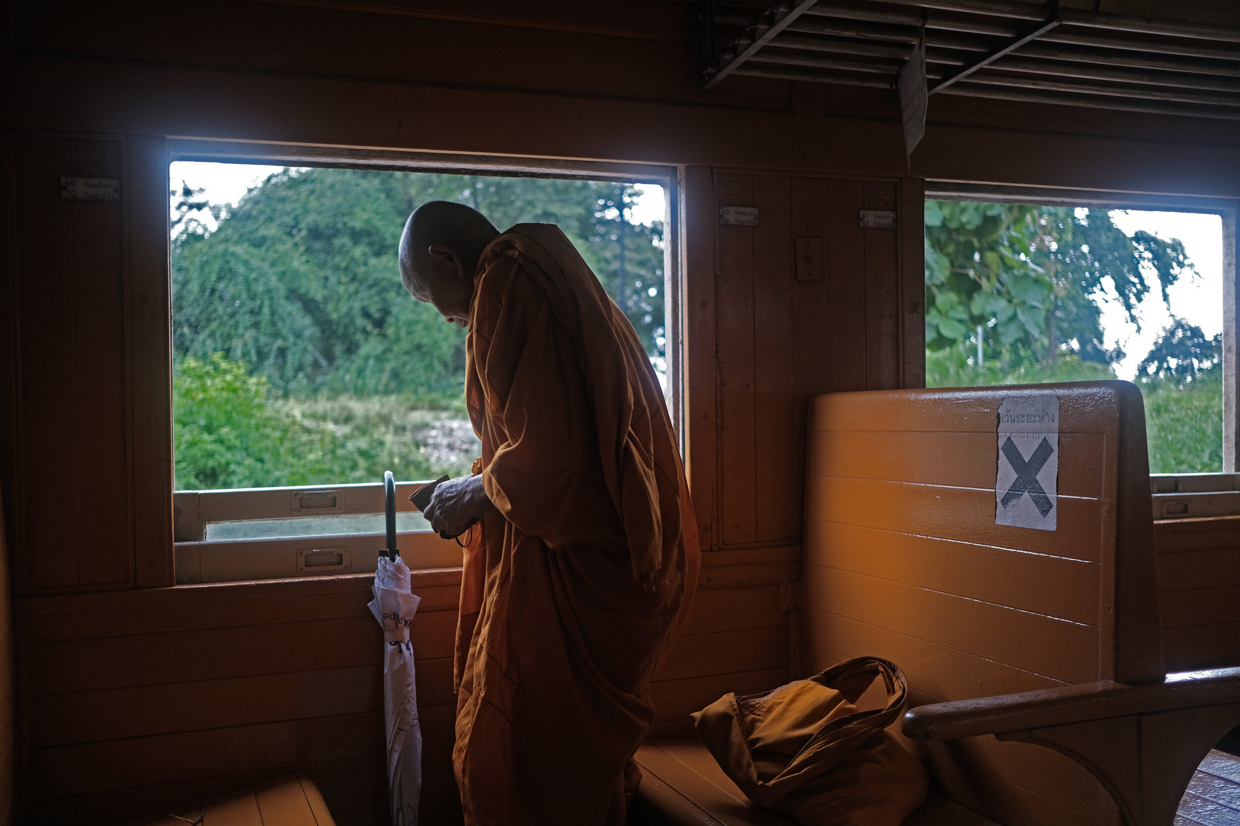  A Buddhist Monk boards for the journey to Bangkok. The train travels along the infamous ‘death railway’ built by Allied prisoners of war during World War II. 