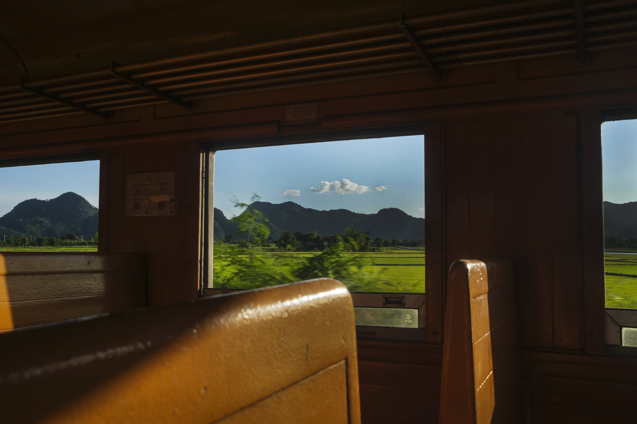  Blue hills, mountains and green rice fields fill the view between River Kwai Bridge station and Nam Tok. 