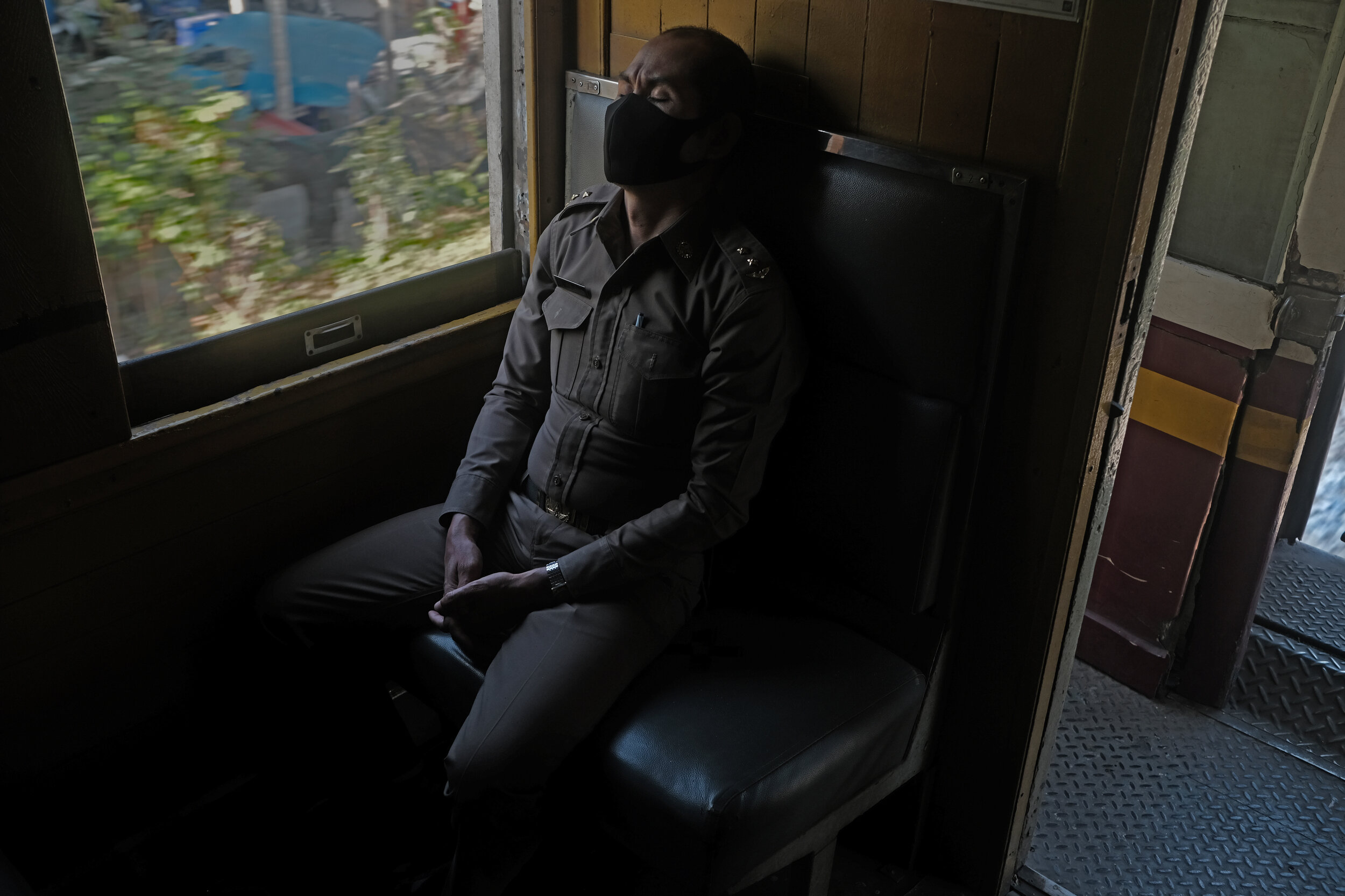  Dhamma Dreaming. Train conductor taking a break on the return journey to Bangkok Thonburi Station. 