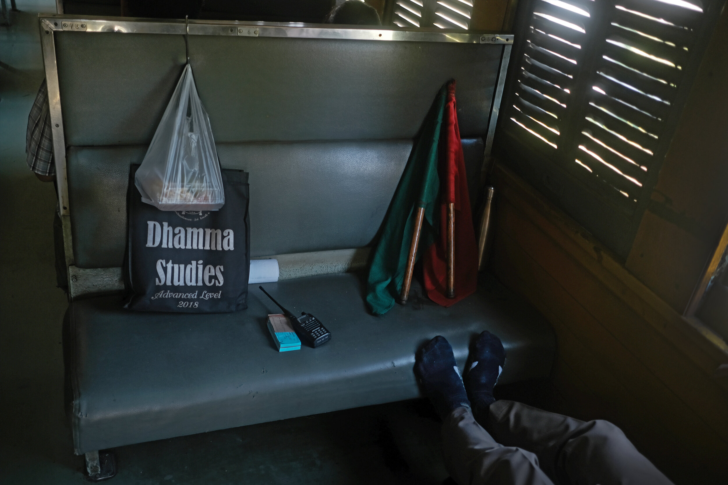  Dhamma Dreaming. Train conductor taking a break on the return journey to Bangkok Thonburi Station. 