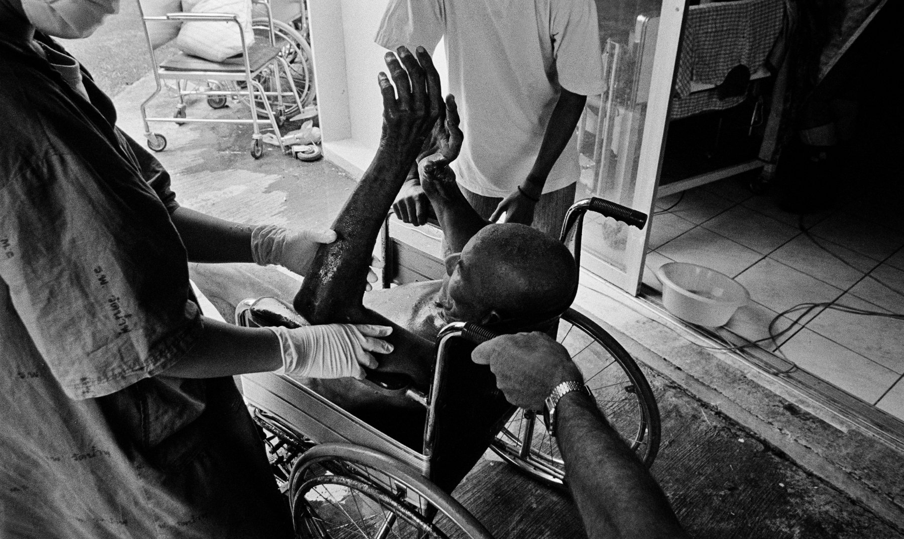  “Care” Volunteer carers bathe patients at Wat Prabat Nampu. Wat Prabat Nampu is a Buddhist temple and a hospice for those living with HIV. Lopburi, Thailand. 2003. 