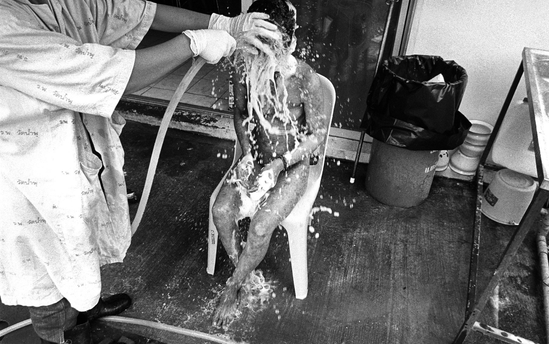  “Care” A volunteer carer bathes a patient at Wat Prabat Nampu. Wat Prabat Nampu is a Buddhist temple and a hospice for those living with HIV. Lopburi, Thailand. 2003. 