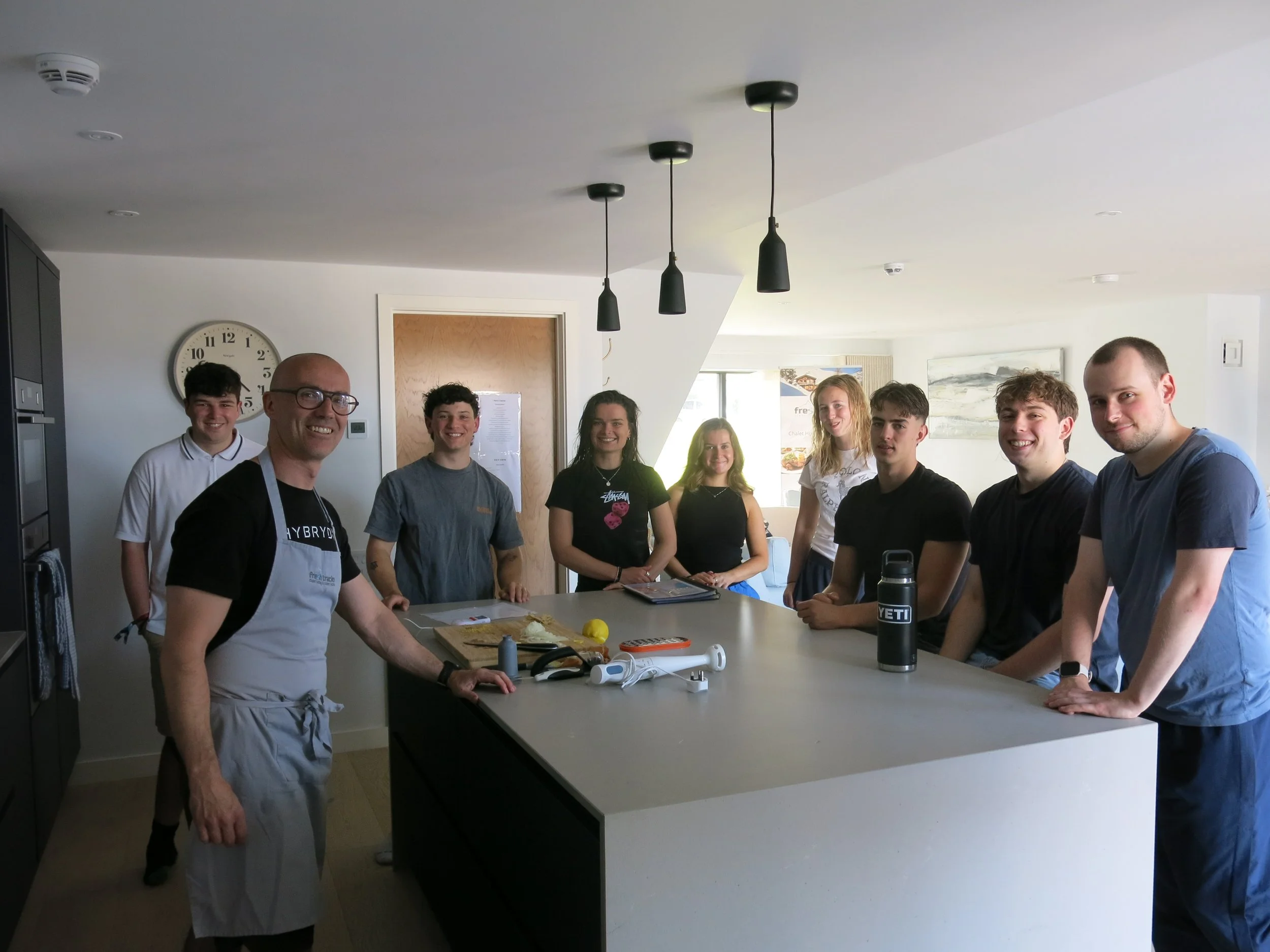 Cooking tutor giveing a demonstration to a group of students