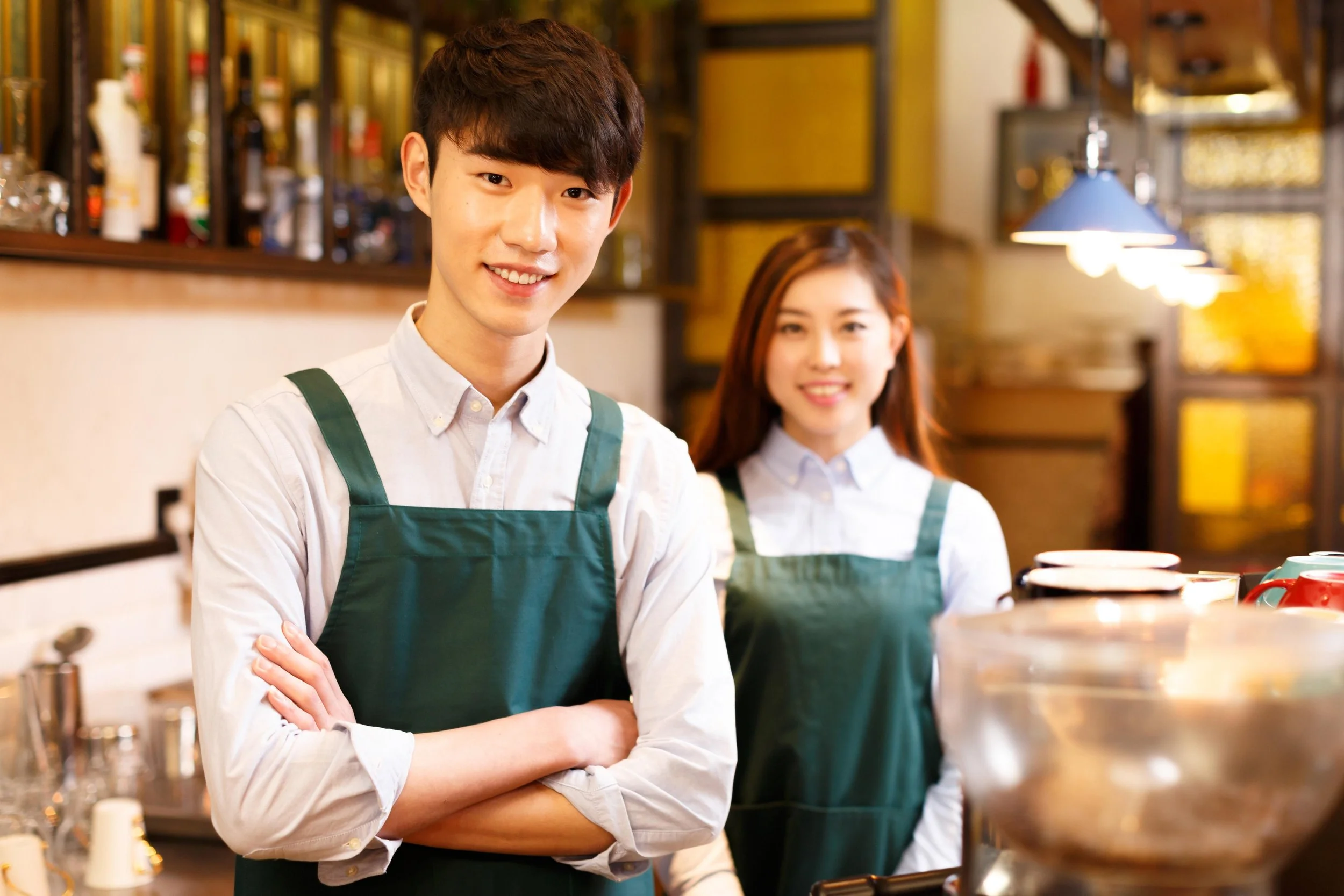 Two young people working in a coffee shop/bar