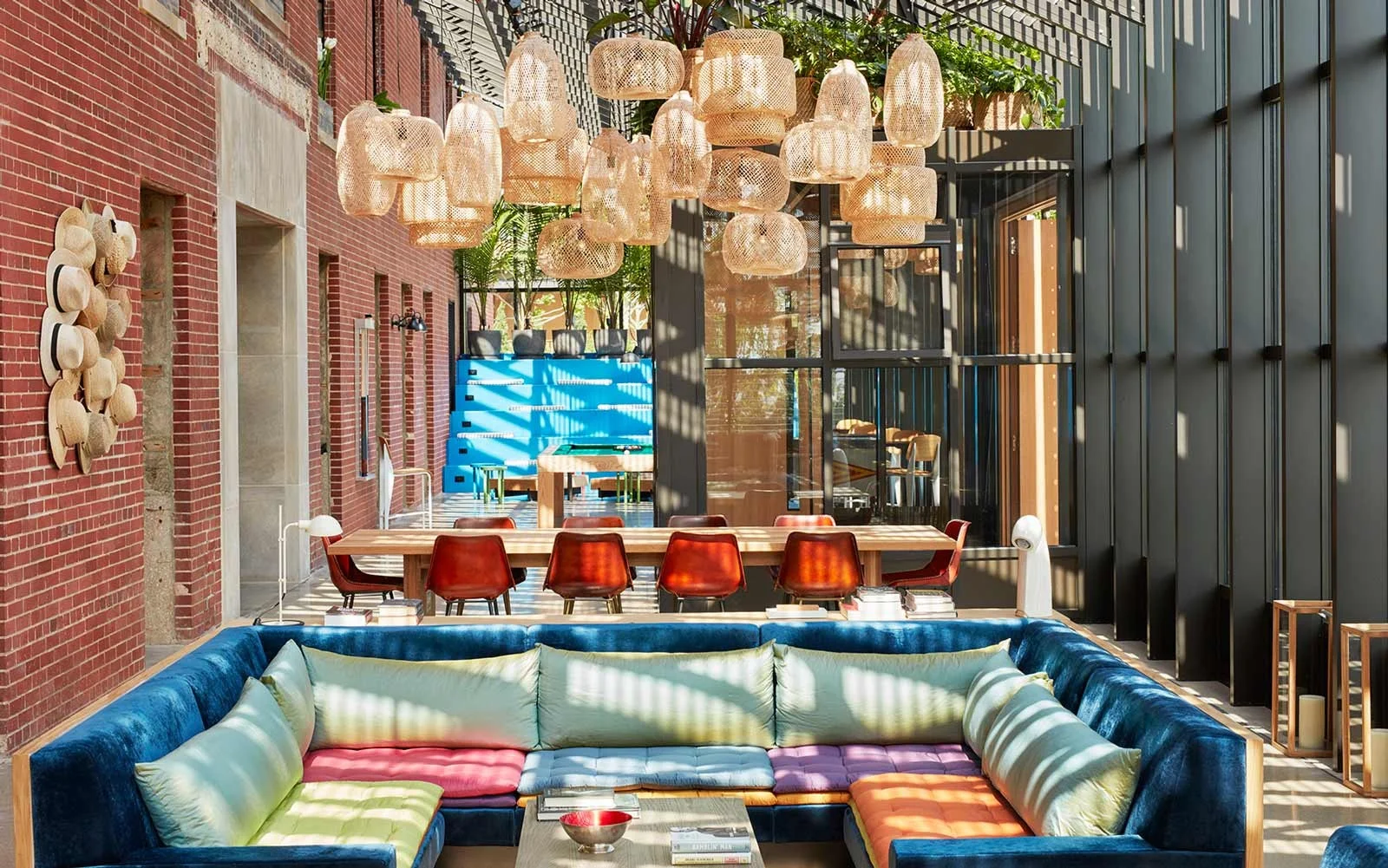 The Lobby. Sunny green room. Colorful sunken couches with hanging basket lights.
