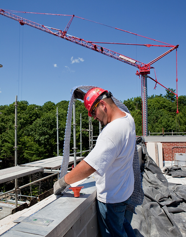 Consigli laborer installing drainage mat at parapets.jpg