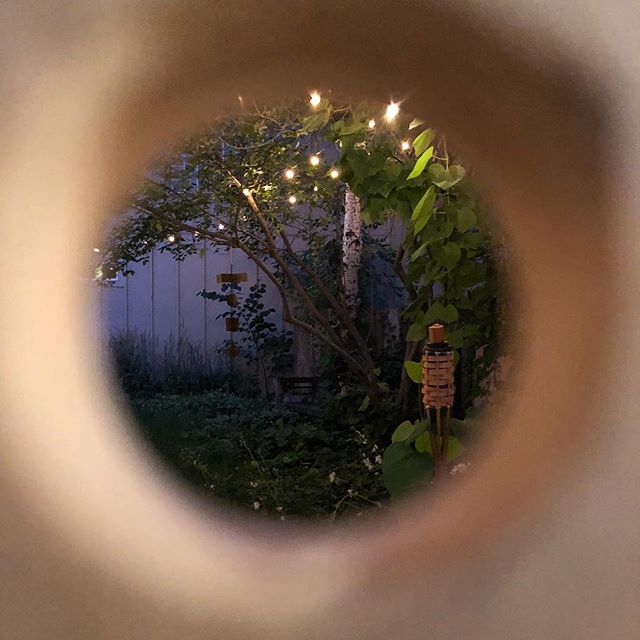 Prepping for @fireflyhandmade tomorrow and caught this twinkly garden view through a peg hole in the @jaspersocialclub display. 👁 🕳