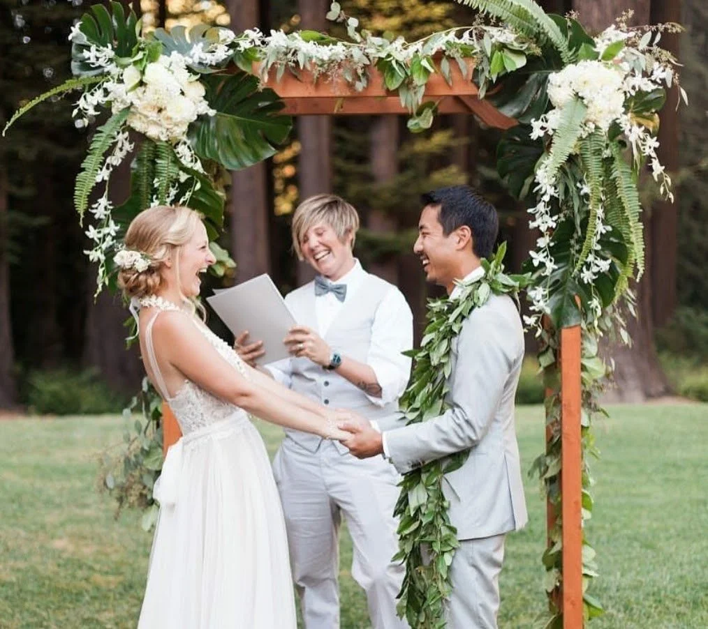 Love Celebrant Lauren Snead laughing with a couple during their joyful outdoor wedding ceremony