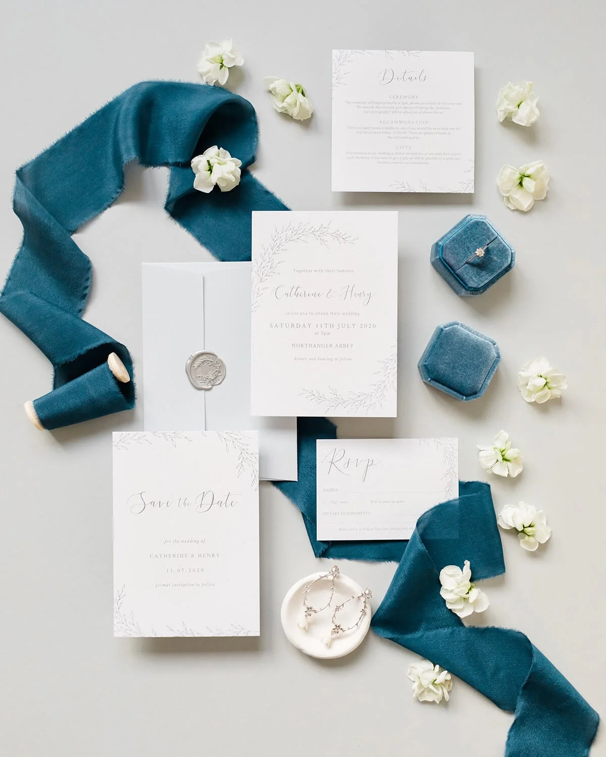 wedding stationery flat lay with blue and grey theme, A6 invitation with botanical wreath design