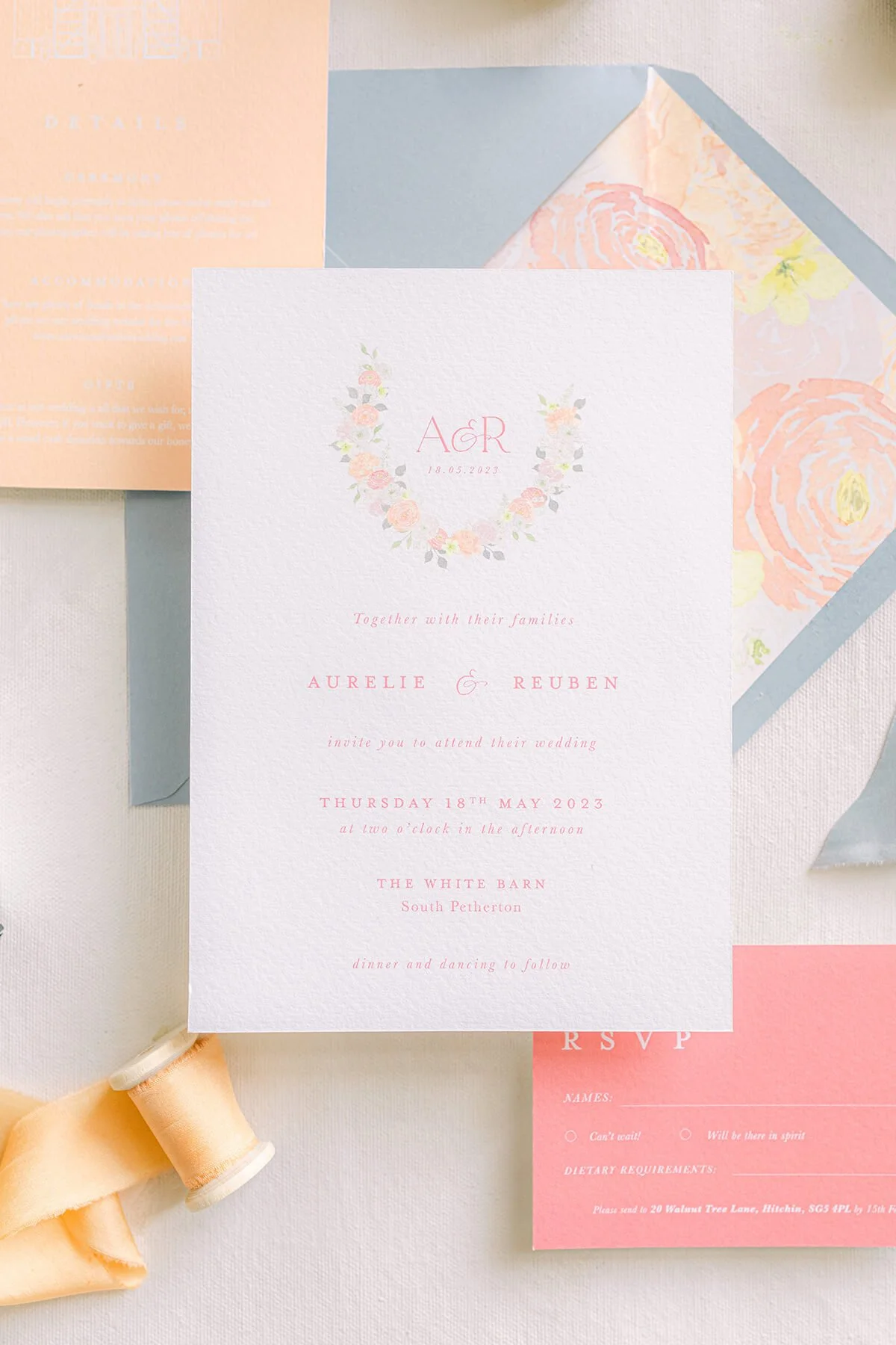 close up of wedding invitation with floral watercolour wreath and monogram