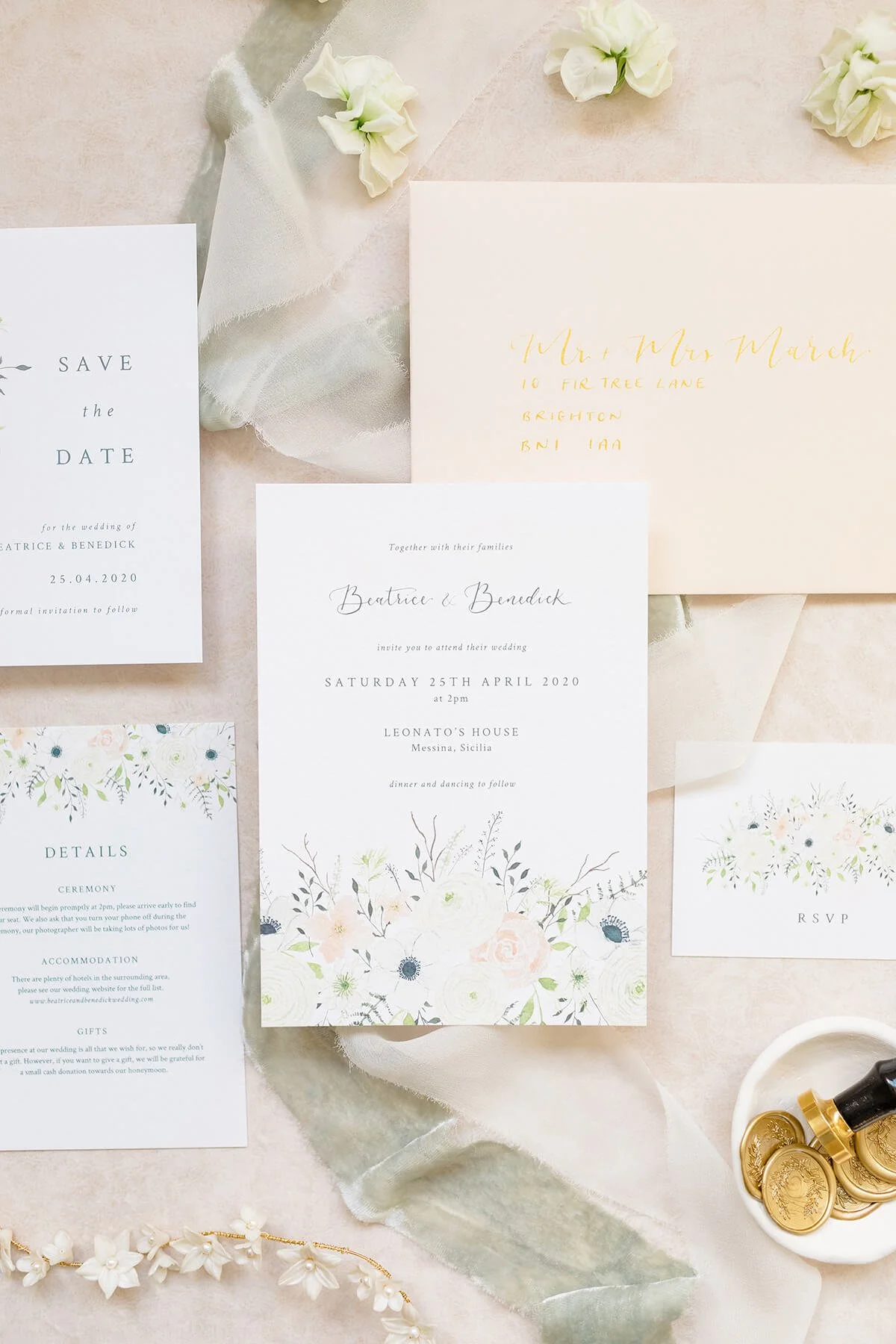 close up of wedding stationery flat lay with invitation, save the date, details and rsvp card with peach envelope and gold calligraphy addressing