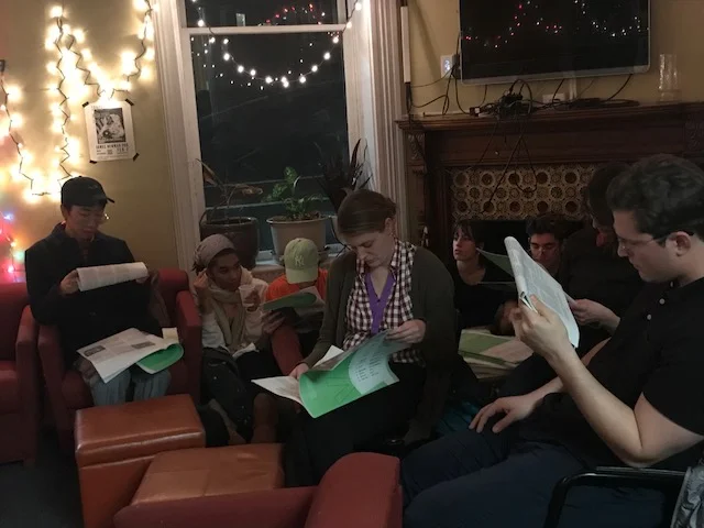 Tiger Dingsun reads from “The Unbearable Whiteness of Being (A Graphic Designer),” while the crowd reads along.