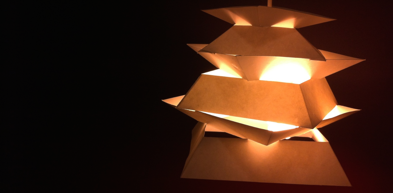 Derived from the simplistic structures of pagodas, Sutakku both reflects and traps light. Its various sized trapezoidal tiers only allow soft light to escape from the edges, as the rest gently glows from within. From this model of the final design, you can see how the placement of these tiers prevent any harsh light from leaving and instead project the light from the bulb upwards against the fixture itself.