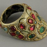  Northern India | Archer’s thumb ring; gold set with rubies and emeralds, with white enamel lotus motifs. Green enamel lotus design on the inside.| 19th century | 