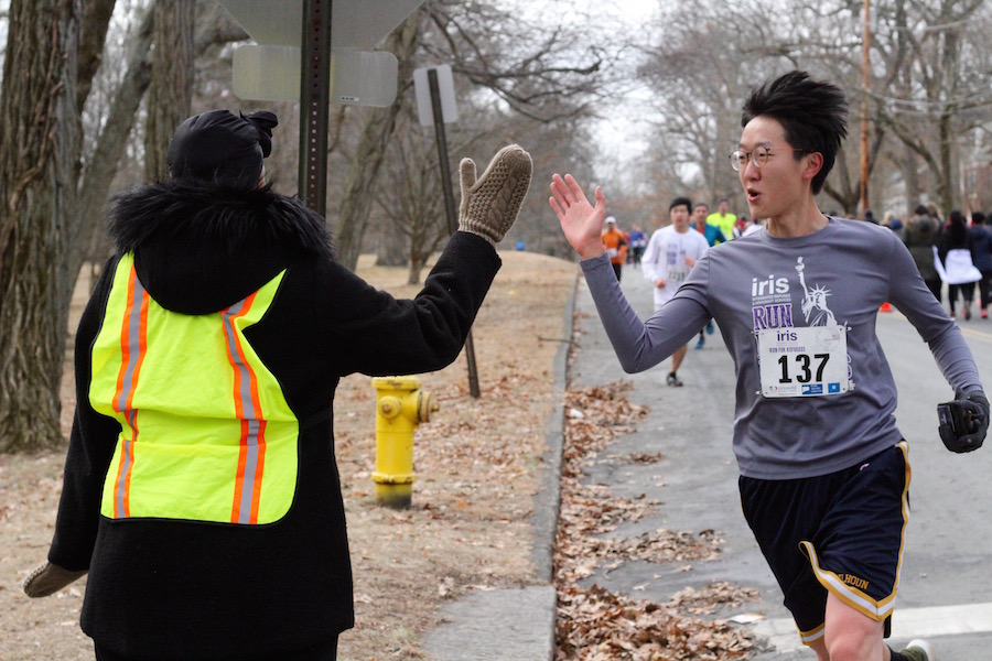 Runner Dennis Wang, a student at the Yale School of Medicine and graduate of the Yale School of Public Health, hits the three mile mark, and gets some support from a race volunteer. 