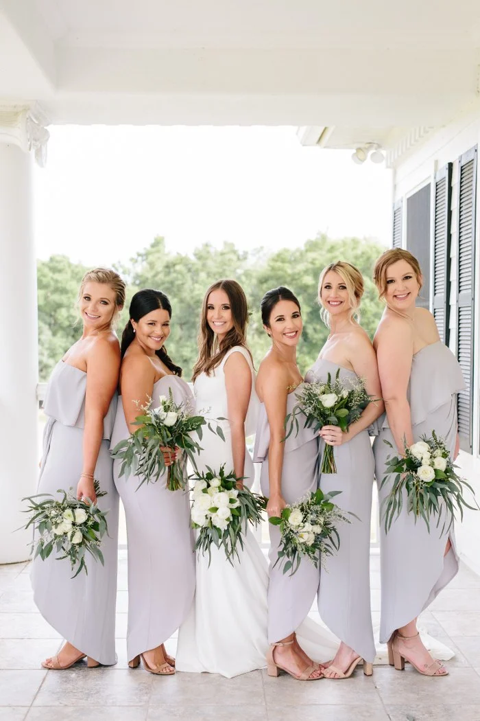 Ashley is wearing a crepe theia couture wedding dress with a chapel train and cowl back