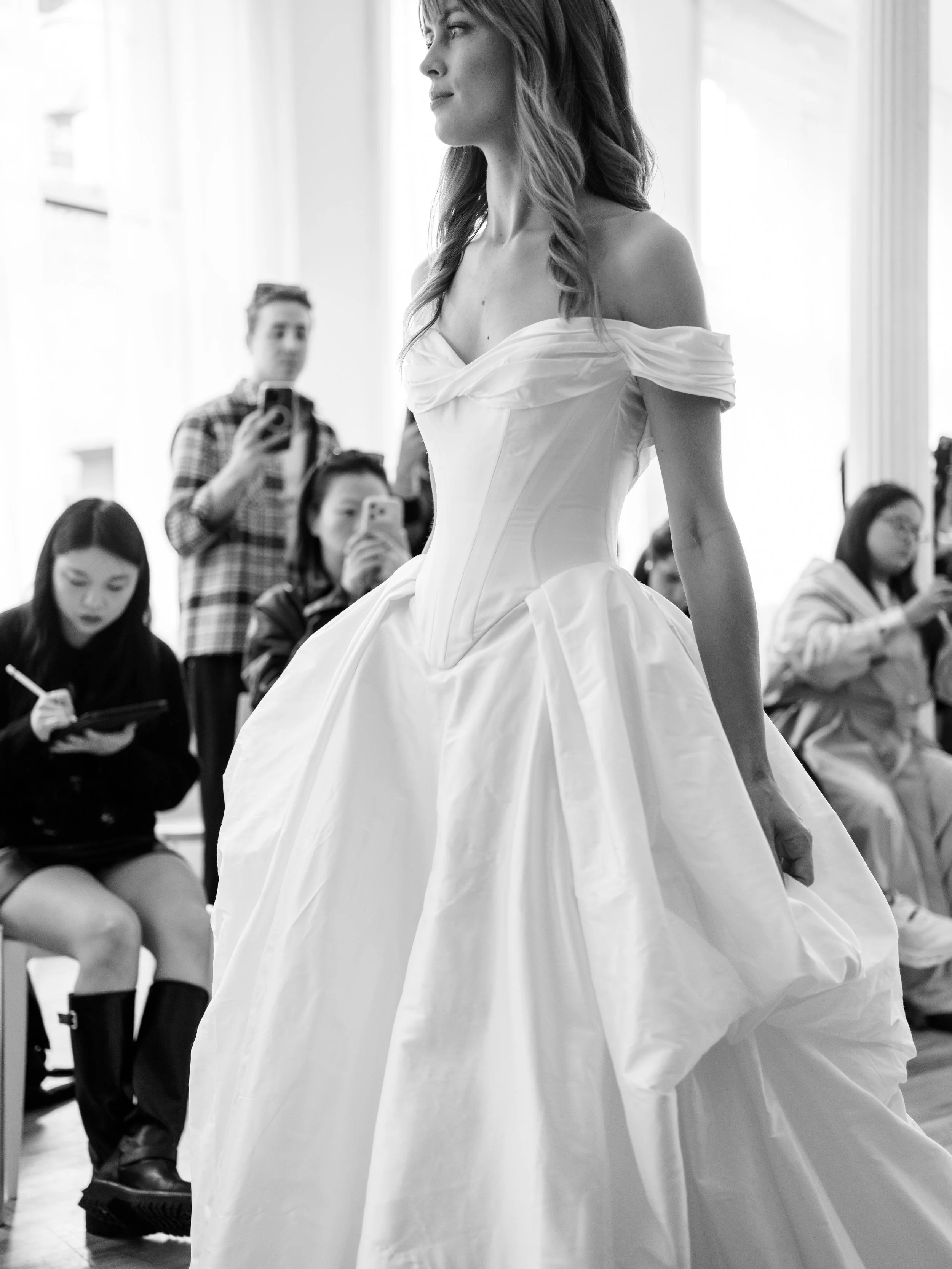 Clean corseted ball gown wedding dress with off the shoulder sleeves. Clean basque waist princess dress with pickups on the sides of the skirt for extra volume. Modified sweetheart neckline ballgown wedding dress by Ines Di Santo