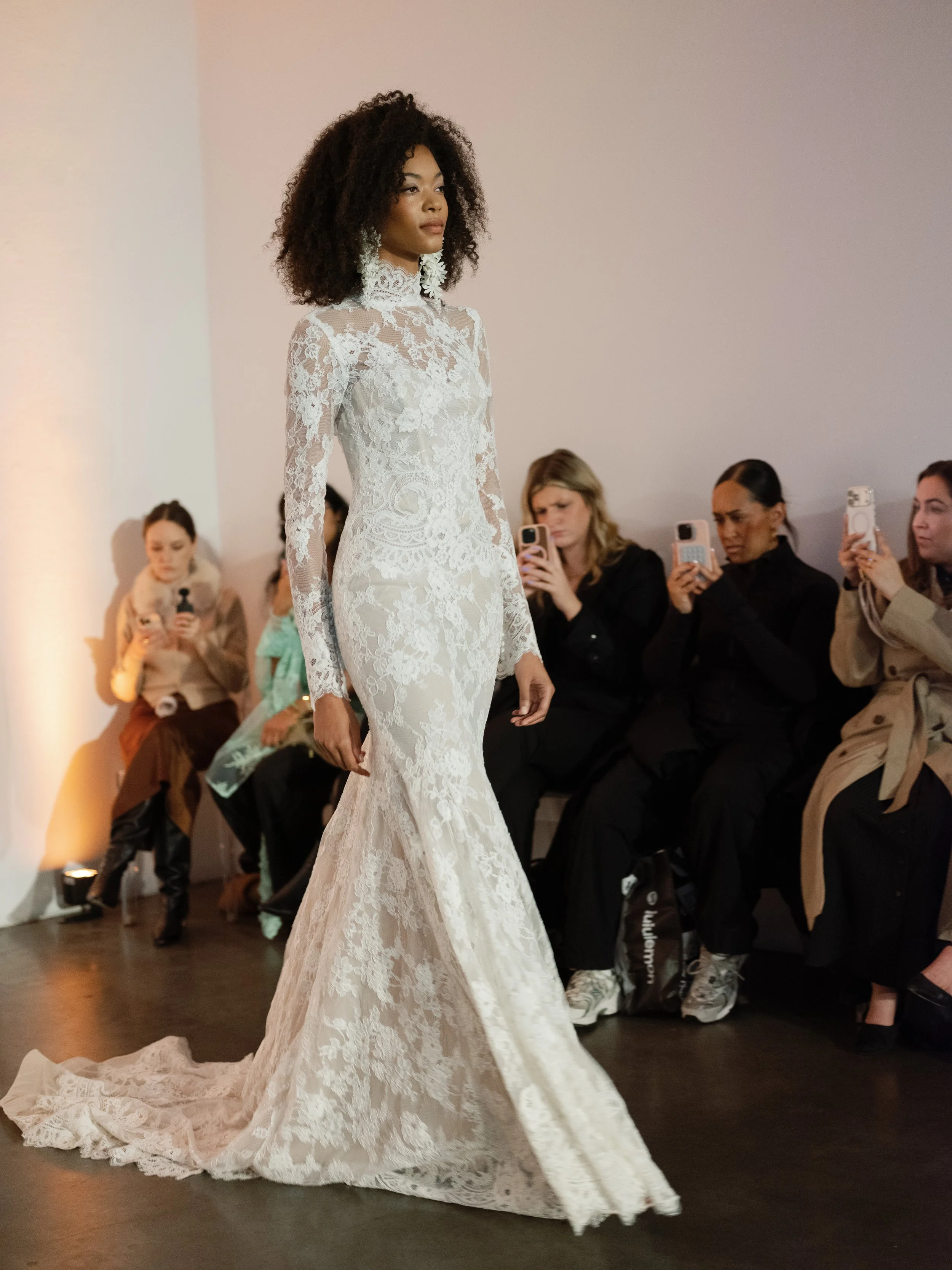 Long-sleeved floral lace mermaid gown with illusion high neckline and sheer sleeves. Full long sleeve lace wedding dress with high neck detail designed by Lihi Hod