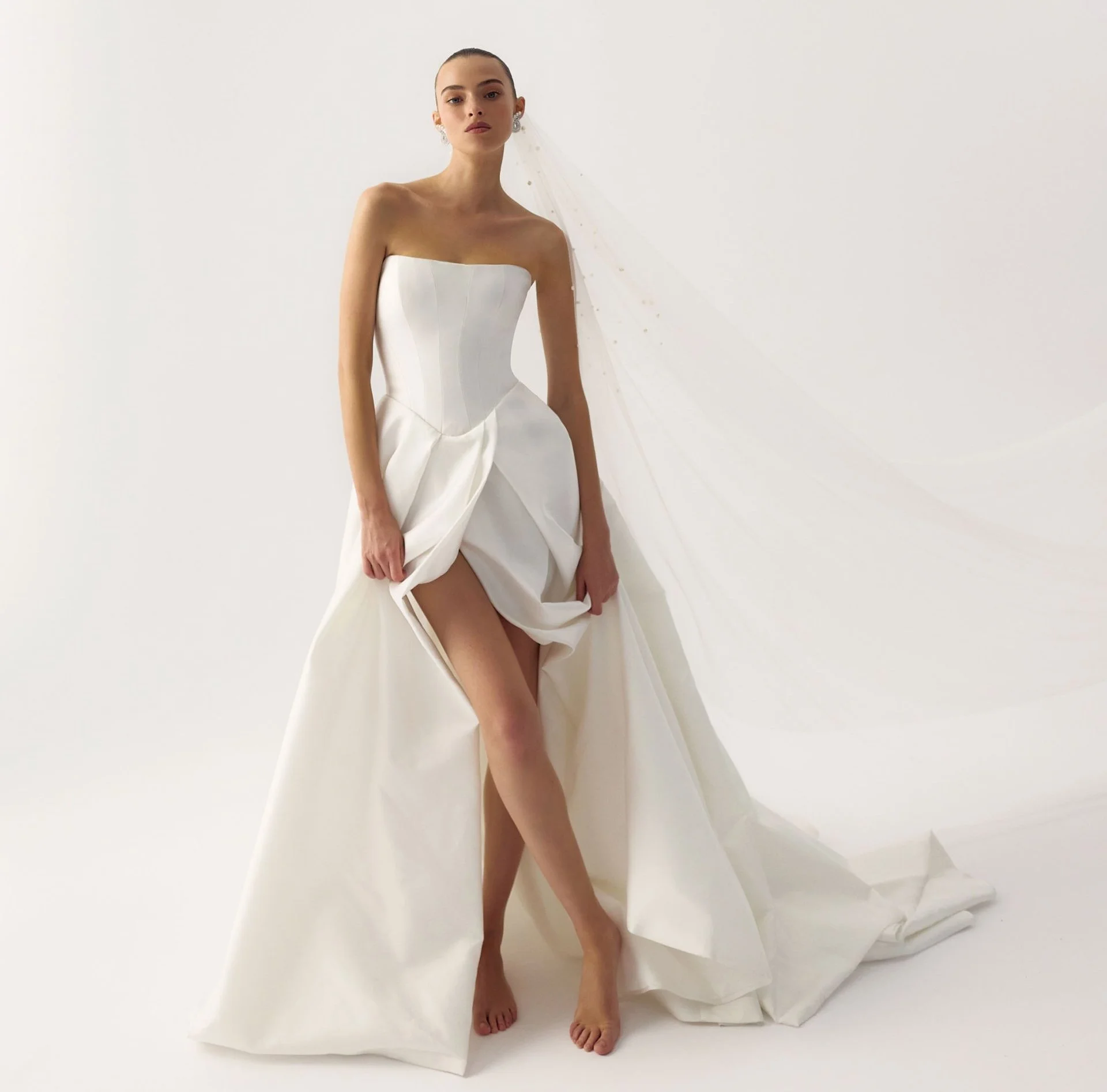 Lihi Hod clean wedding dress with basque waist and dramatic slit. A line wedding dress with basque waist.